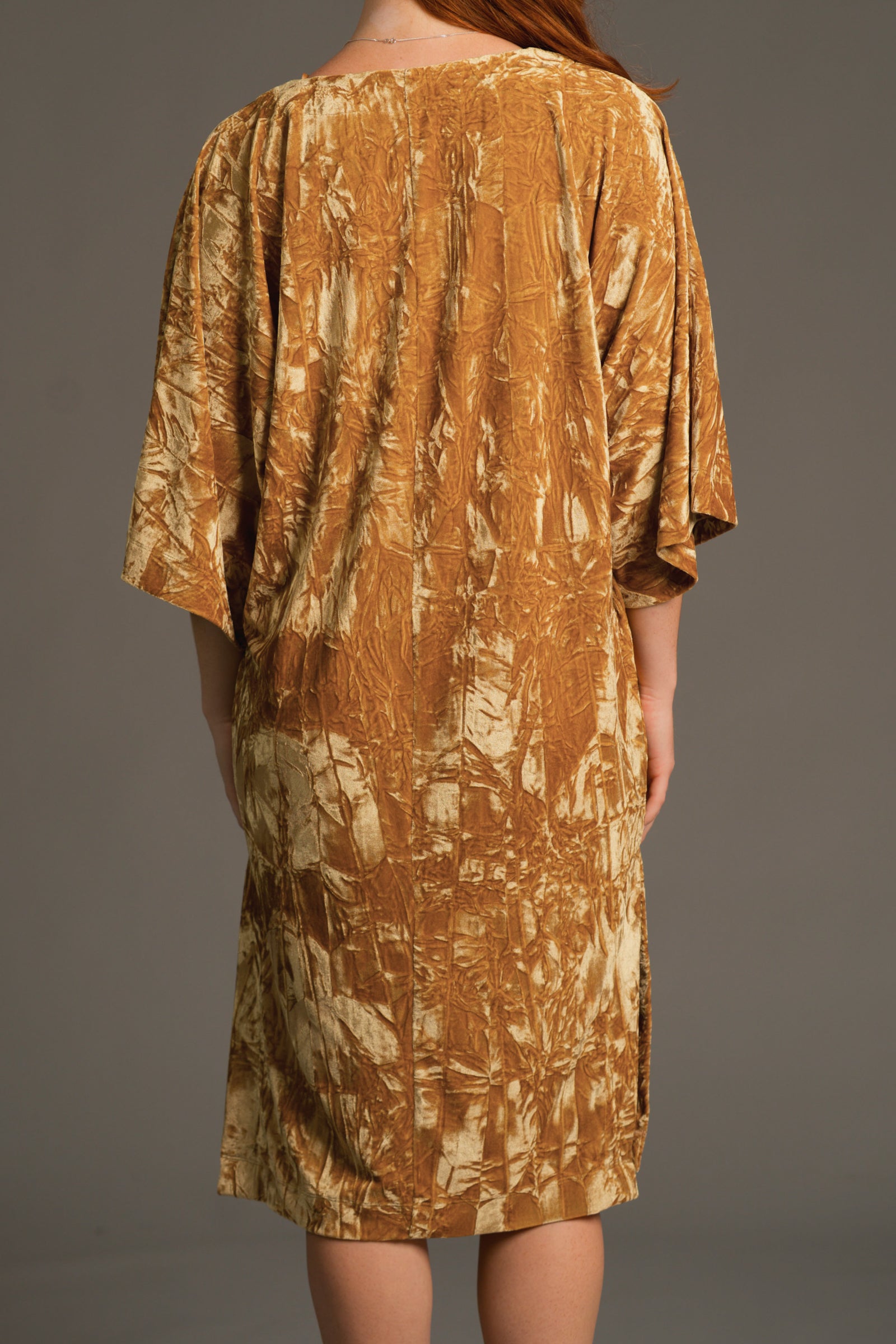 Back view of Rumours ochre velvet dress highlighting relaxed fit and sleeve drape