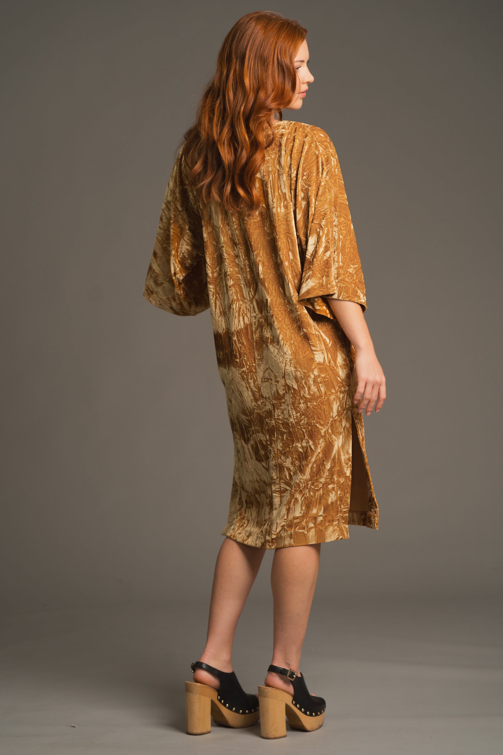 Back view of Rumours ochre velvet dress highlighting relaxed fit and sleeve drape