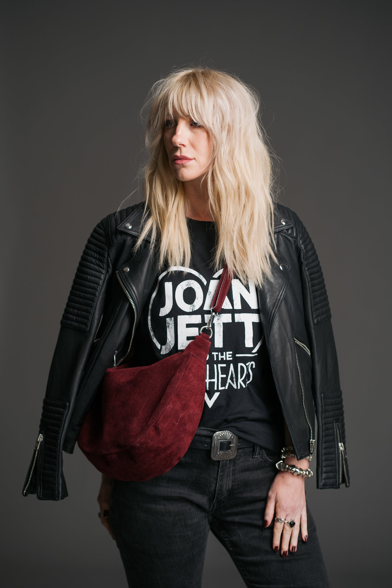 Sienna Oxblood Genuine Suede Sling Bag styled with a black leather biker jacket and graphic band tee.
