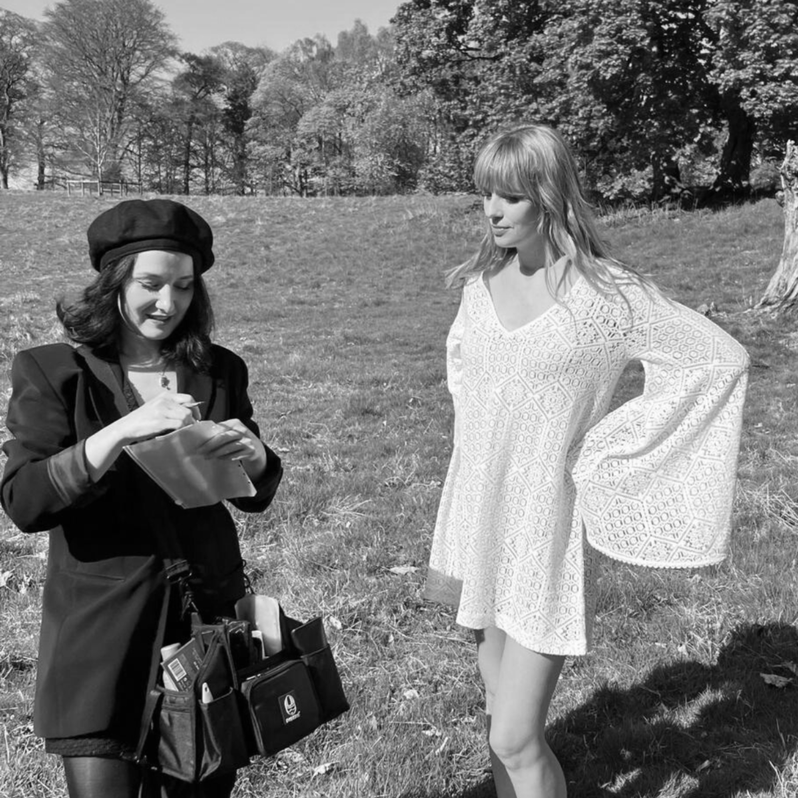 Model and make up artist hatting in festival field. wearing Goldie Crochet Mini dress