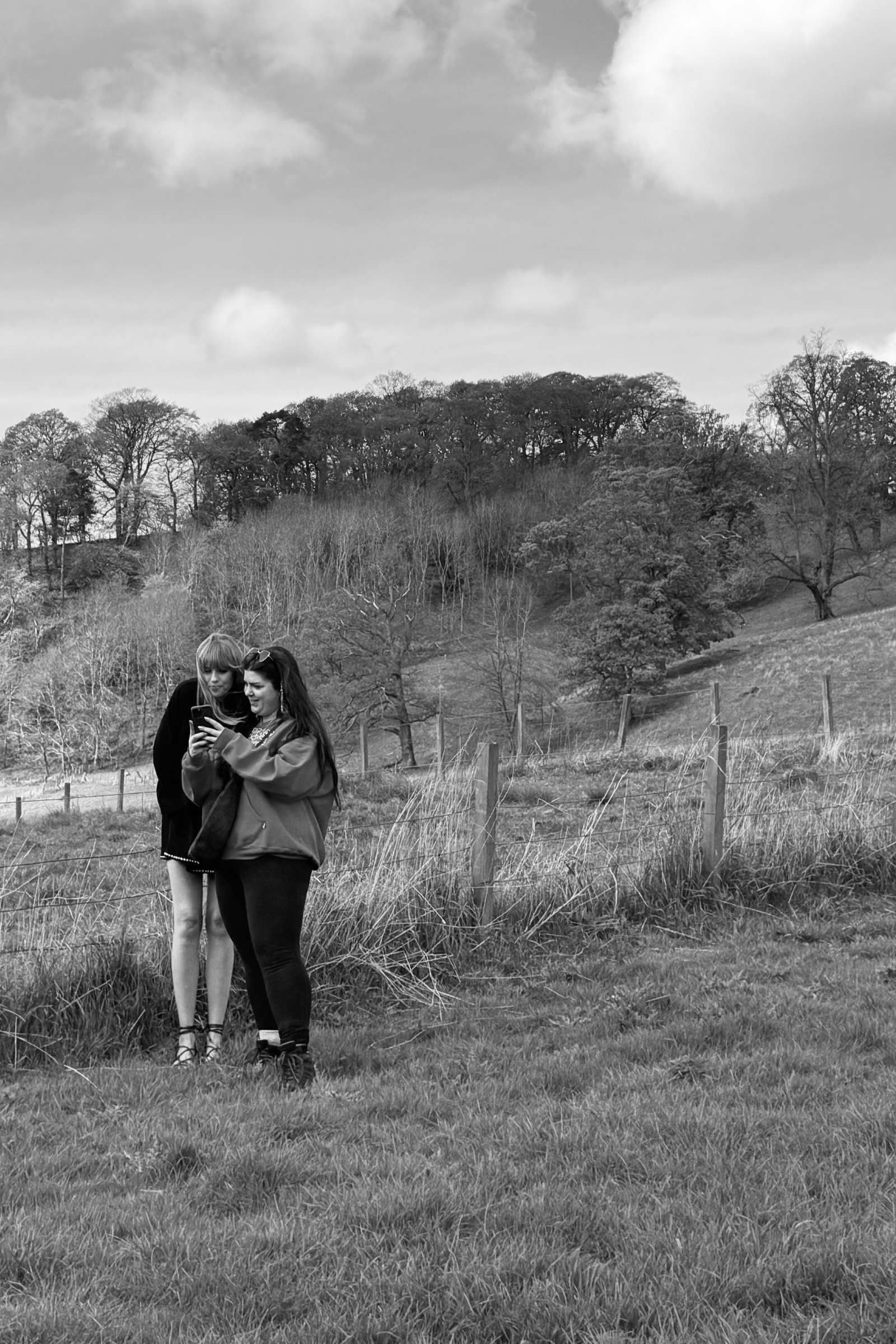 Model and content creator reviewing content in festival field. BTS candid shot.