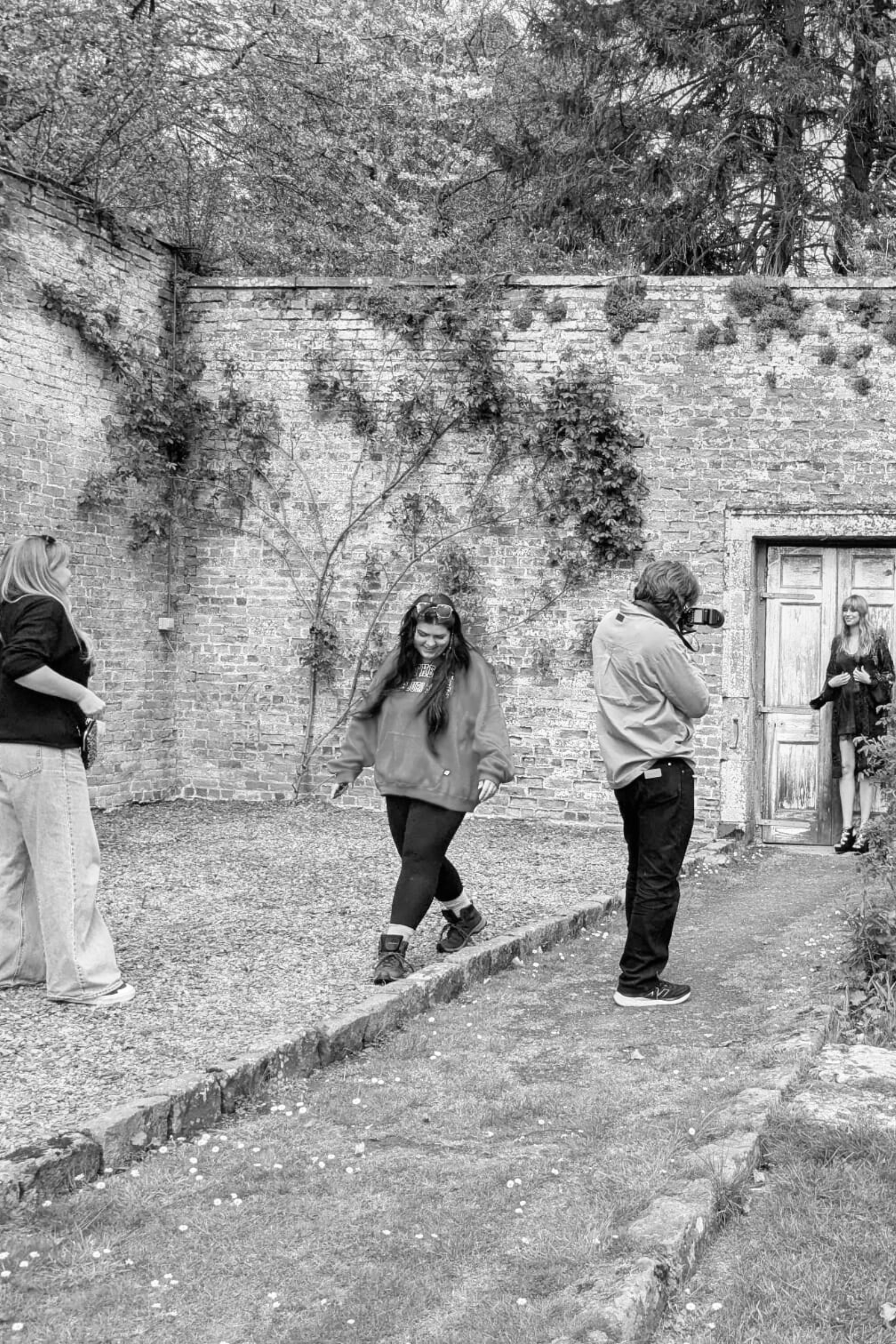 Photoshoot inside walled garden at Inchyra Byre, model being photographed in front of rustic door.