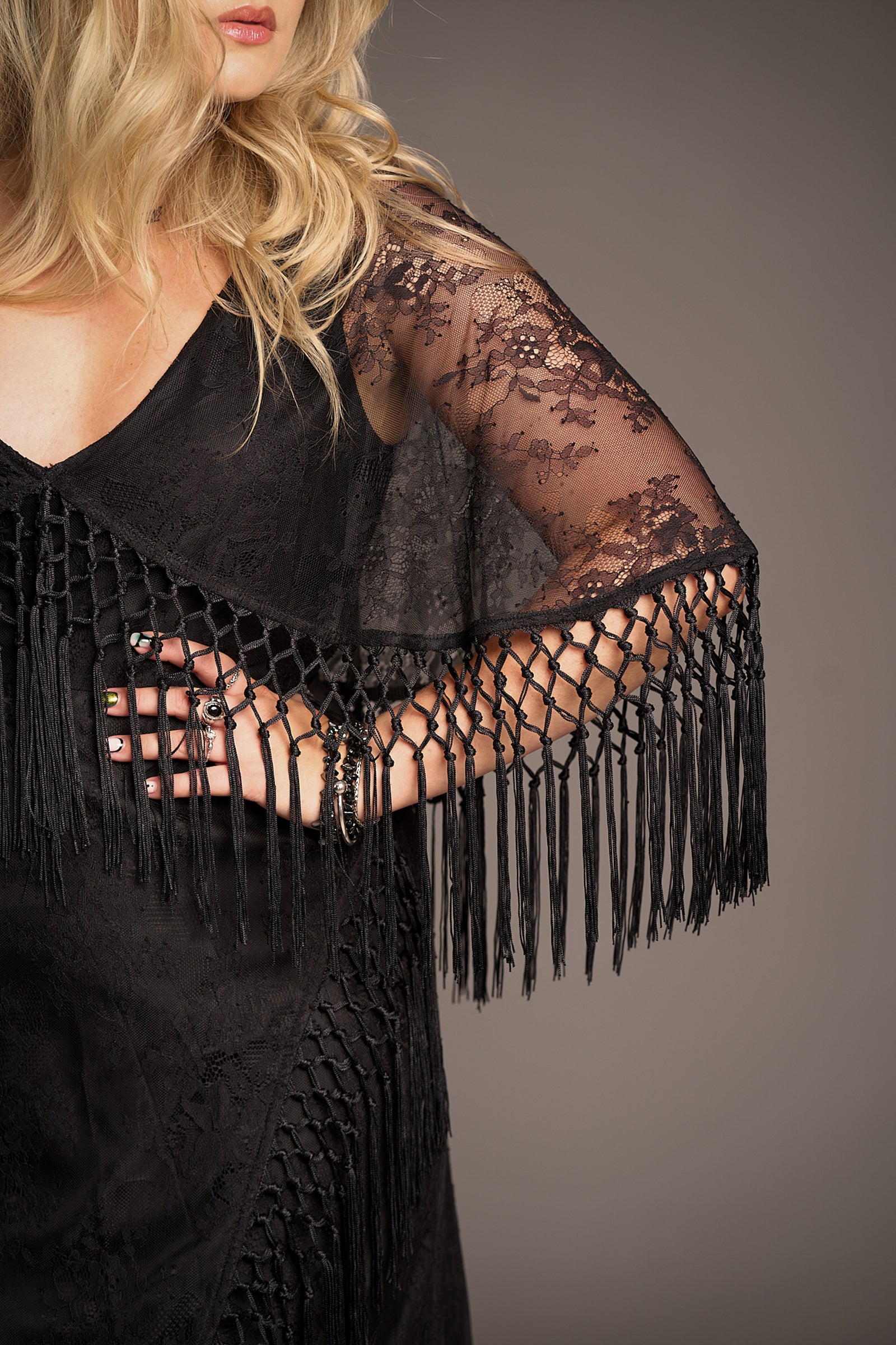 Close up of Erin showcasing the cape and fringe details of the Tango in the Night Lace Midi Dress