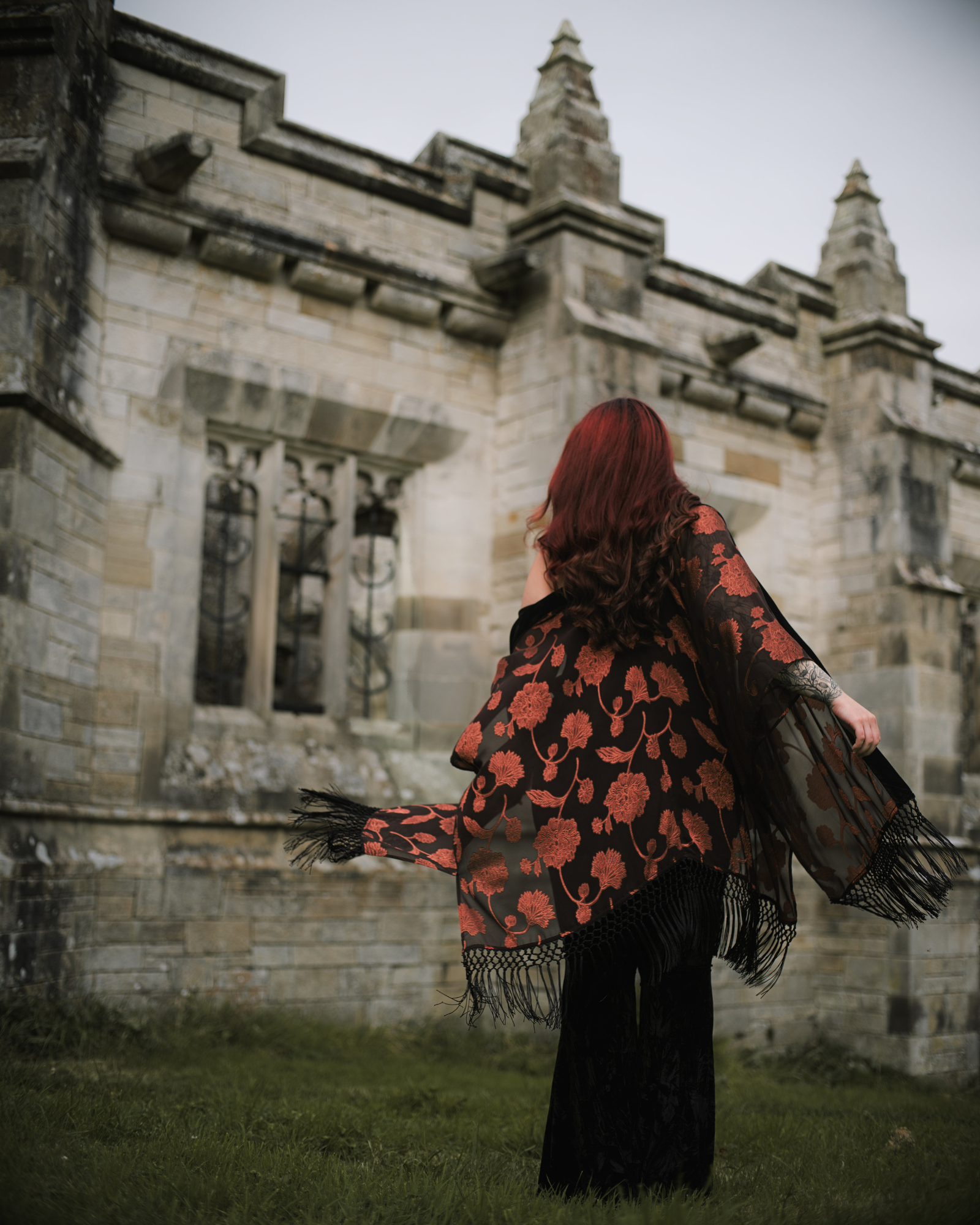 Taylor twirling in the Venus Fringed Kimono in front of gothic stone architecture in a Stevie Nicks inspired shoot