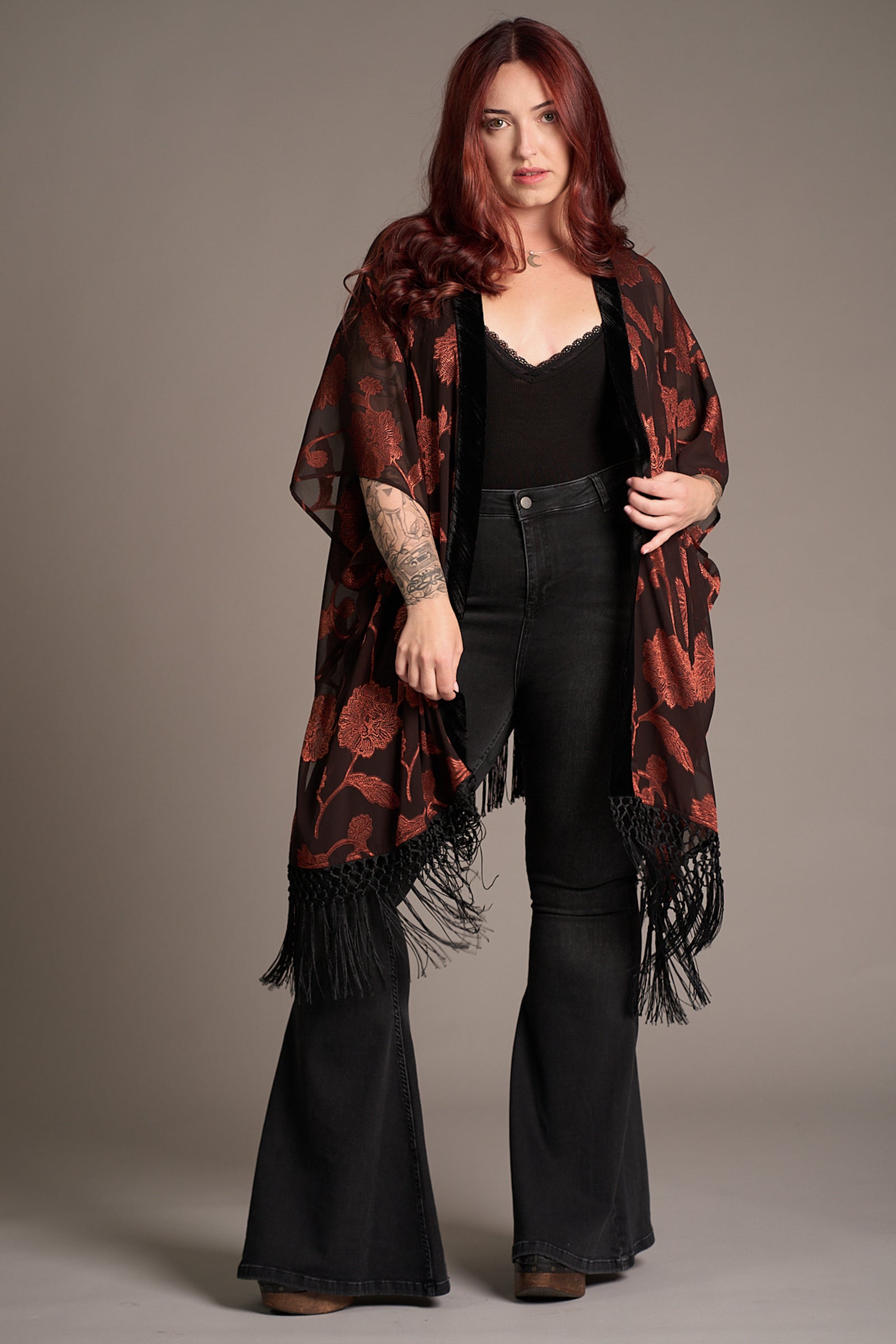 Taylor wears Venus Fringed Kimono with black sheer fabric, red floral print, and fringe hem. Stevie Nicks inspired styling studio