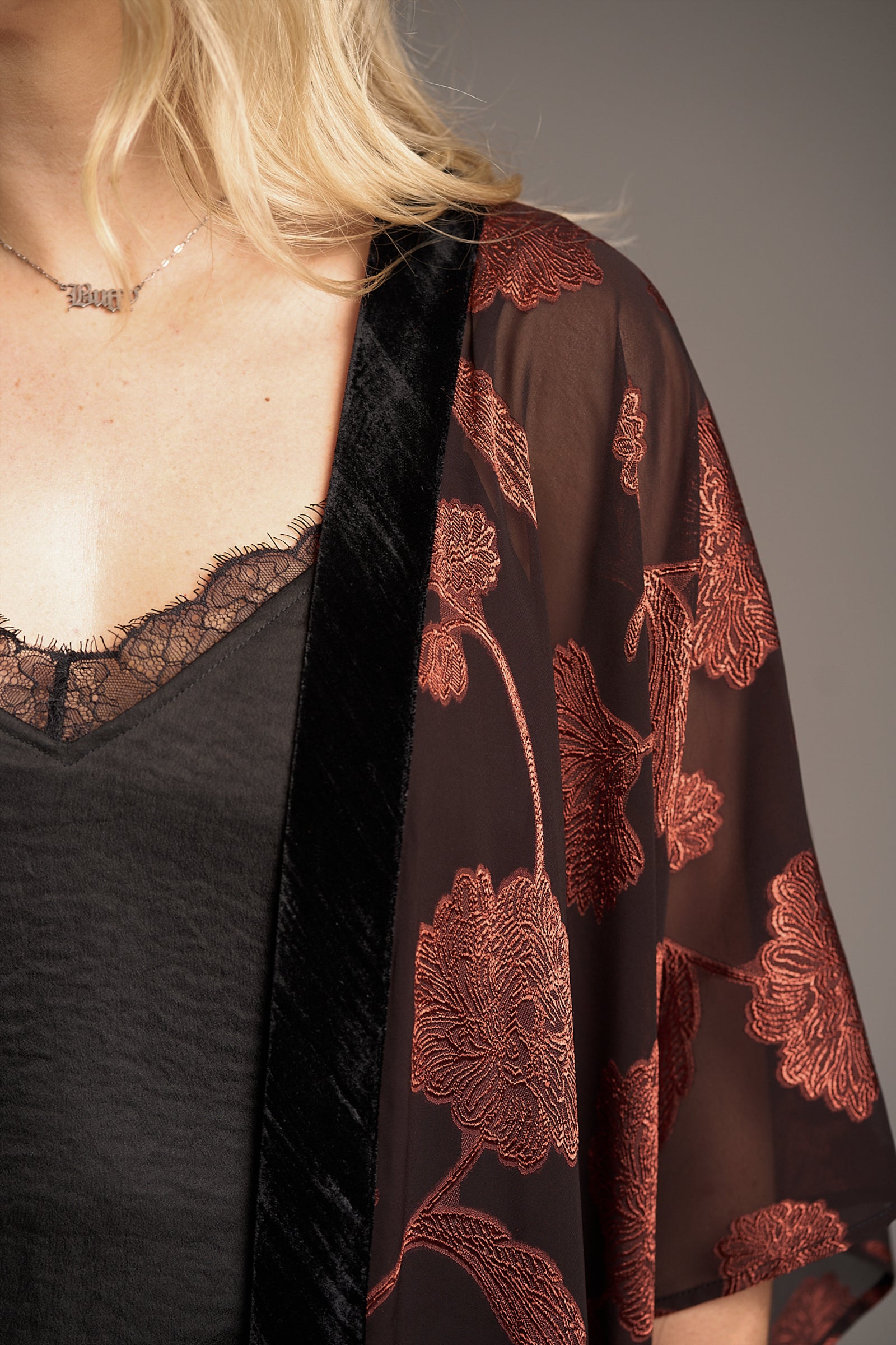 Close-up of Venus Fringed Kimono with sheer black fabric, red floral embroidery, and velvet trim
