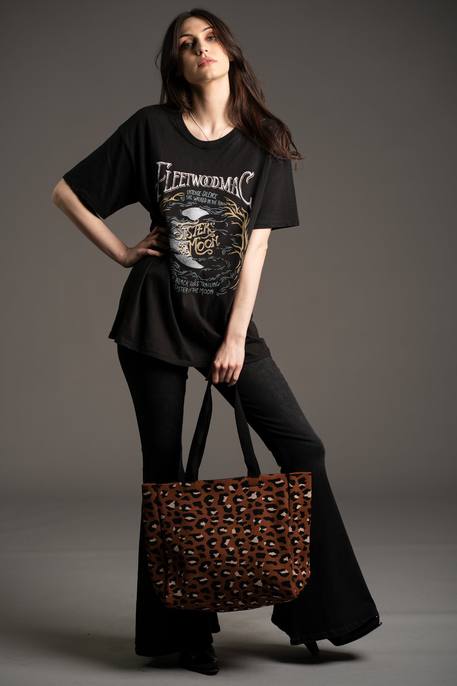 Model Andie wearing Fleetwood Mac graphic band tee and Hendrix Denim flares styled with the Wild Nights Leopard Shopper bag by Little Lies in studio setting