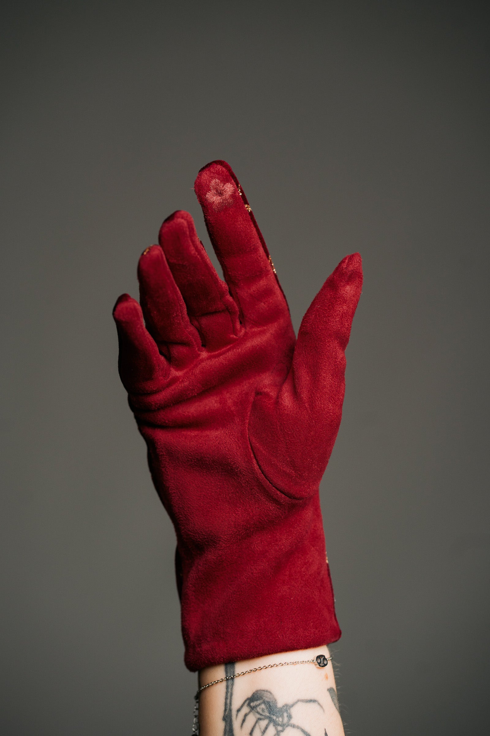 Product shot showcasing the Wine Velvet Celestial Gloves, with rich red fabric with close up of touchscreen friendly tip.