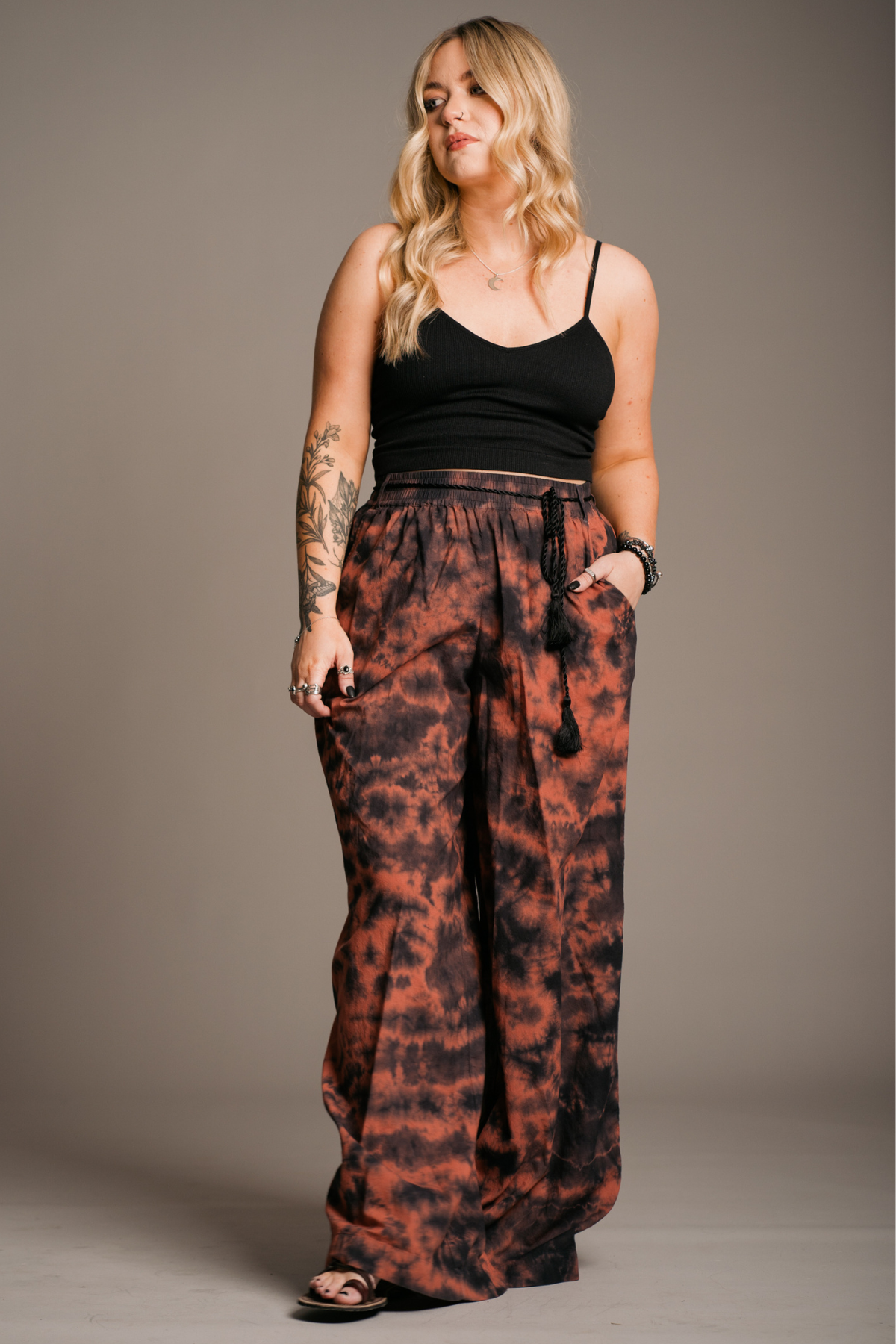 Model wearing the Zephyr tie dye wide leg trouser with black tie tassel waist tie. Beautiful Bohemian style.