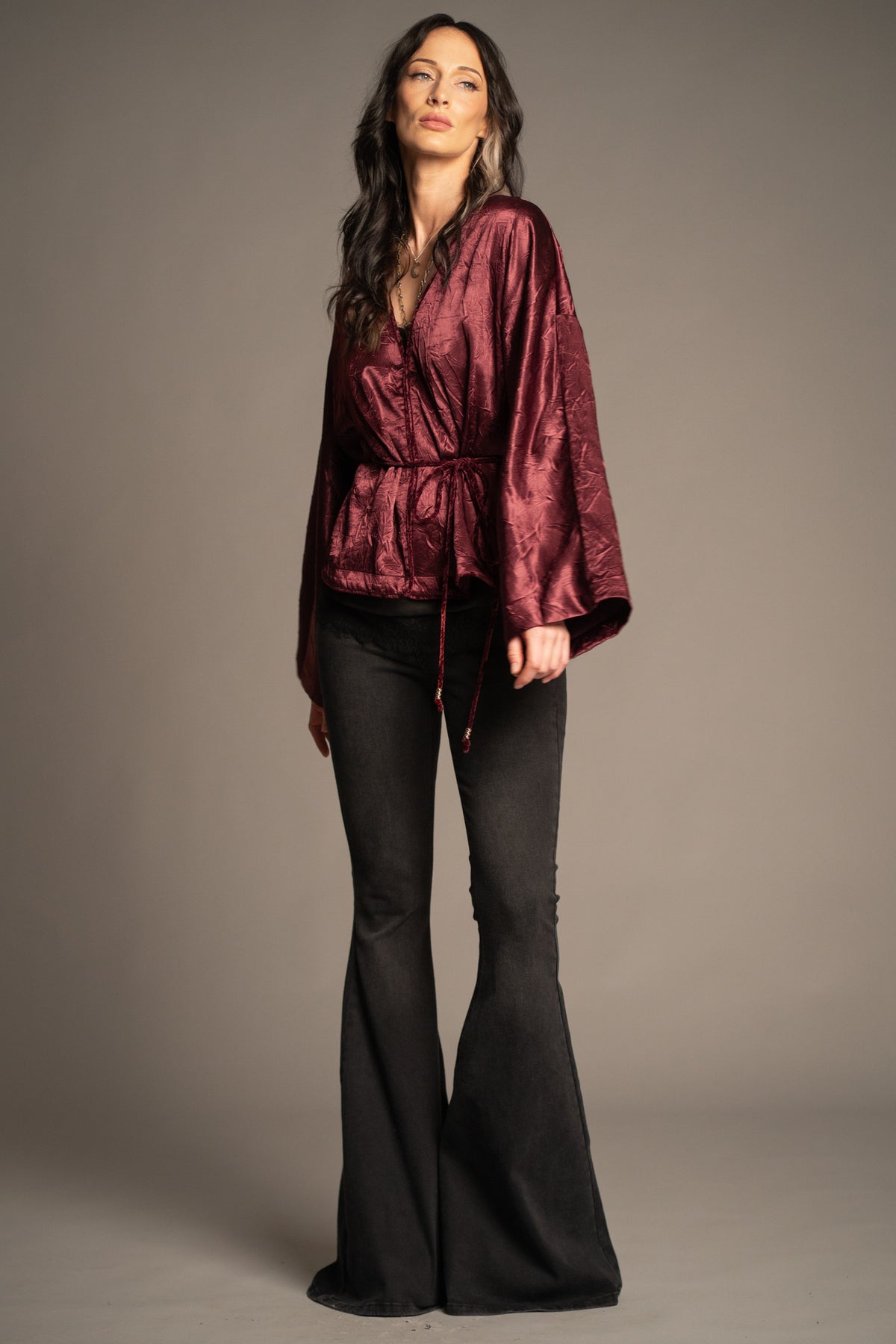 Celeste wine kimono top with hook and eye front closure design, velvet piping detail, beaded tie waist and wide kimono sleeves front view, styled with Hendrix Denim flares.