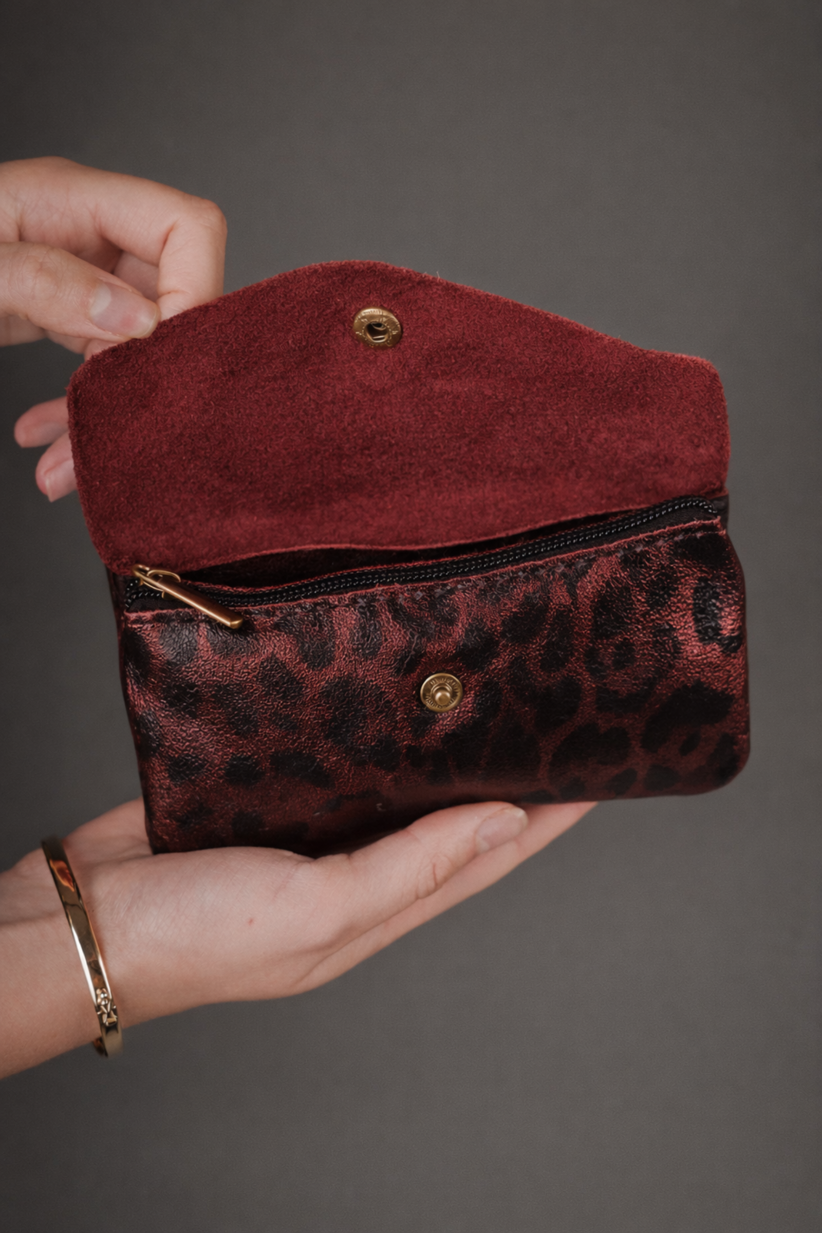 Cherry Red metallic leopard print suede purse held in hand