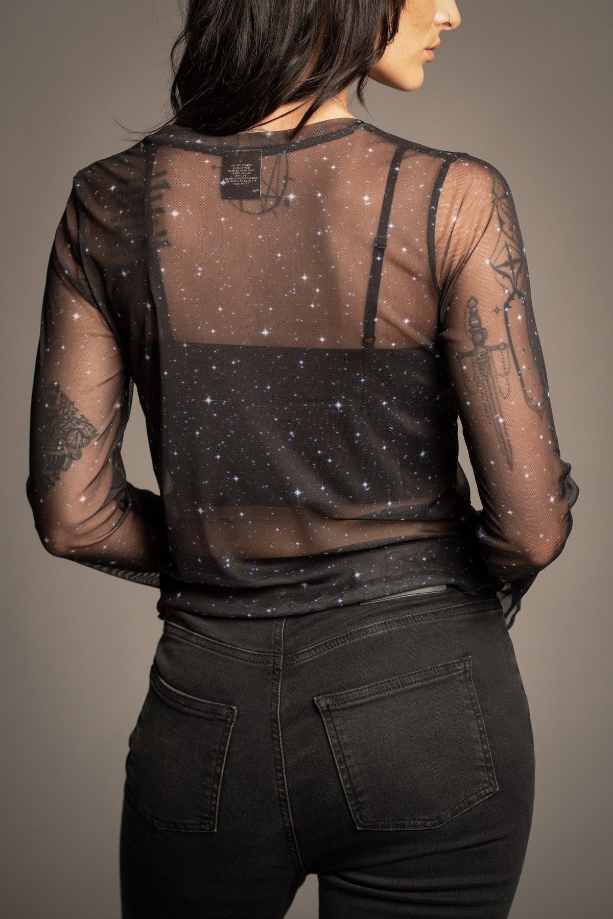 Back view of Victoria wearing the David Bowie Ziggy Stardust sheer black mesh top