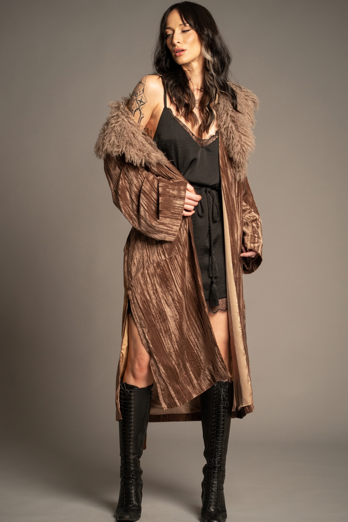 Sienna velvet kimono jacket styled over a belted black lace-trim mini dress with knee-high boots, featuring a dramatic faux fur collar
