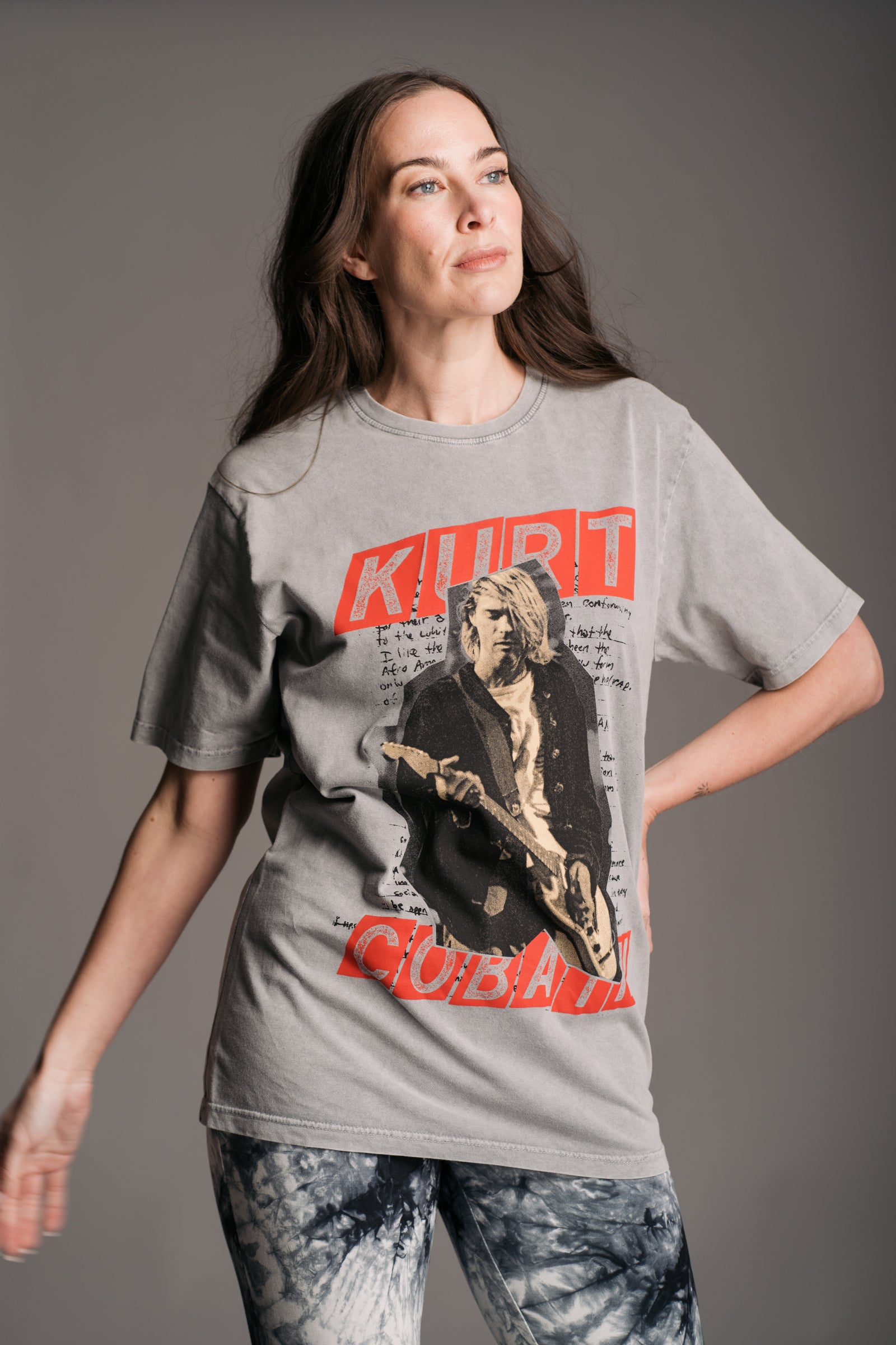 Bex wears unisex grey acid‑wash Kurt Cobain graphic band t‑shirt by Little Lies featuring bold red lettering and vintage‑style print