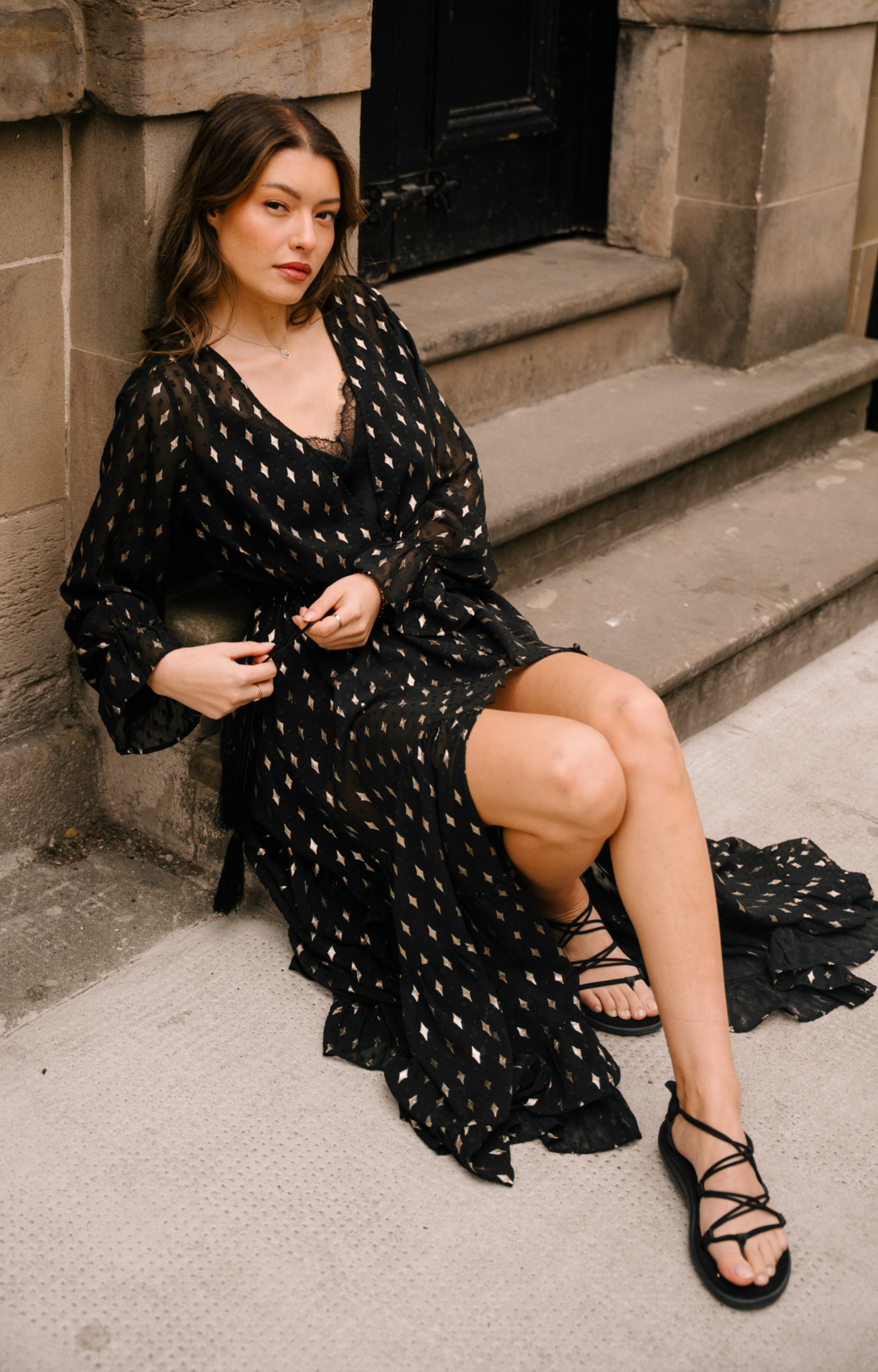 Little Lies Space Oddity Metallic Maxi Dress in sheer black chiffon with gold diamond motifs, worn closed with drawstring waist and tiered ruffle hem
