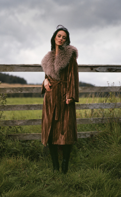 Model wearing the Little Lies Sienna Velvet Kimono Jacket in rich bronze velvet with a statement faux fur collar, photographed outdoors for the Spellbound collection campaign.