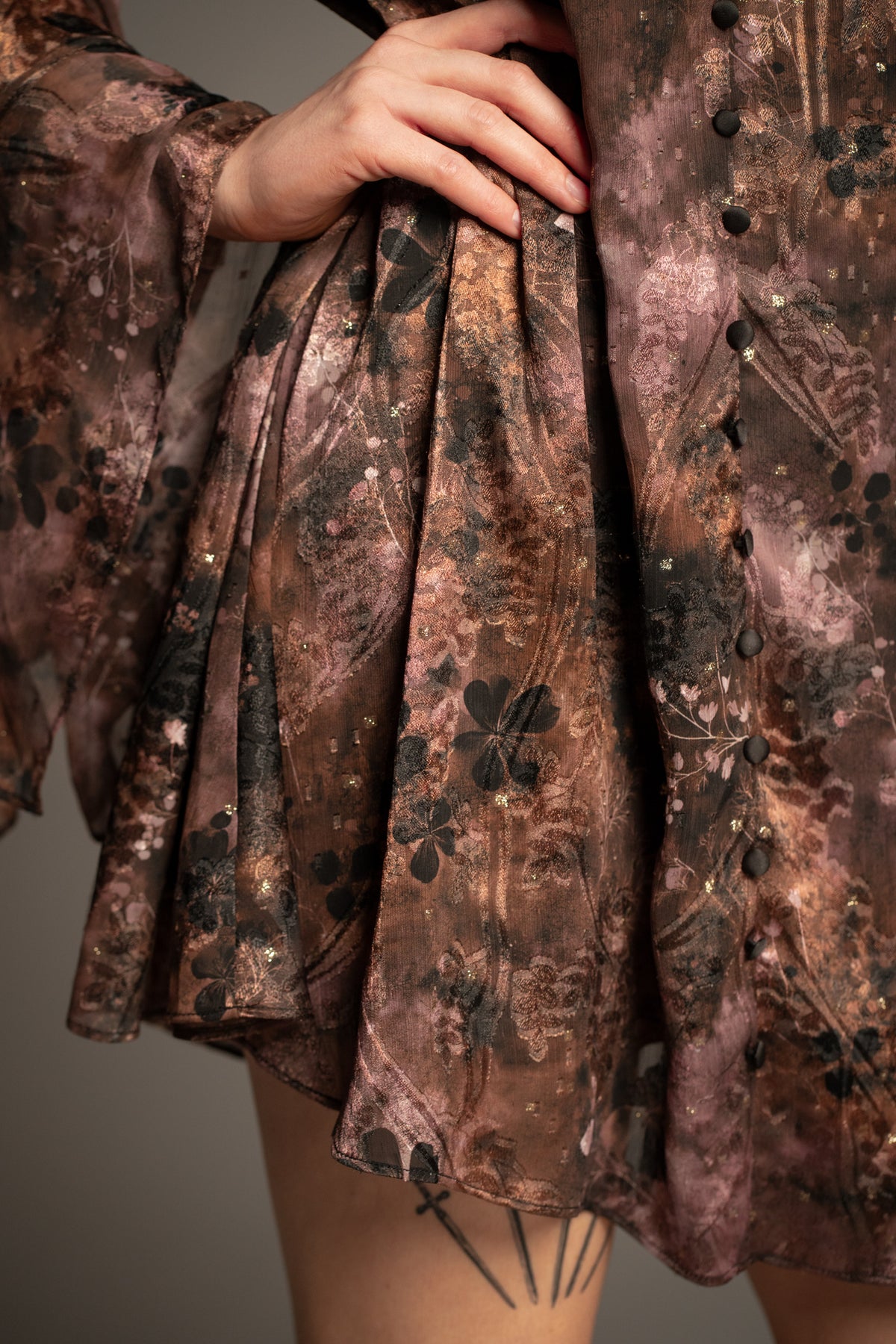 Close-up of Practical Magic mini dress showcasing floral print, covered button detail and lightweight flowing fabric