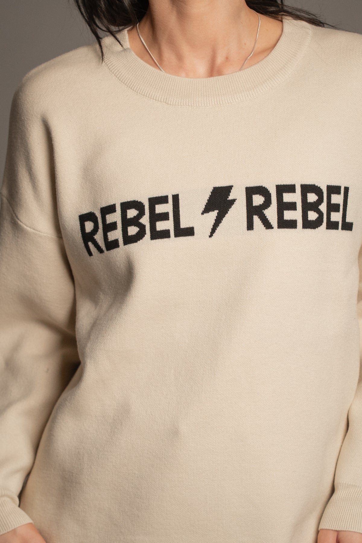 Rebel Rebel Cream Knit Jumper close-up — black REBEL REBEL lettering and lightning bolt detail