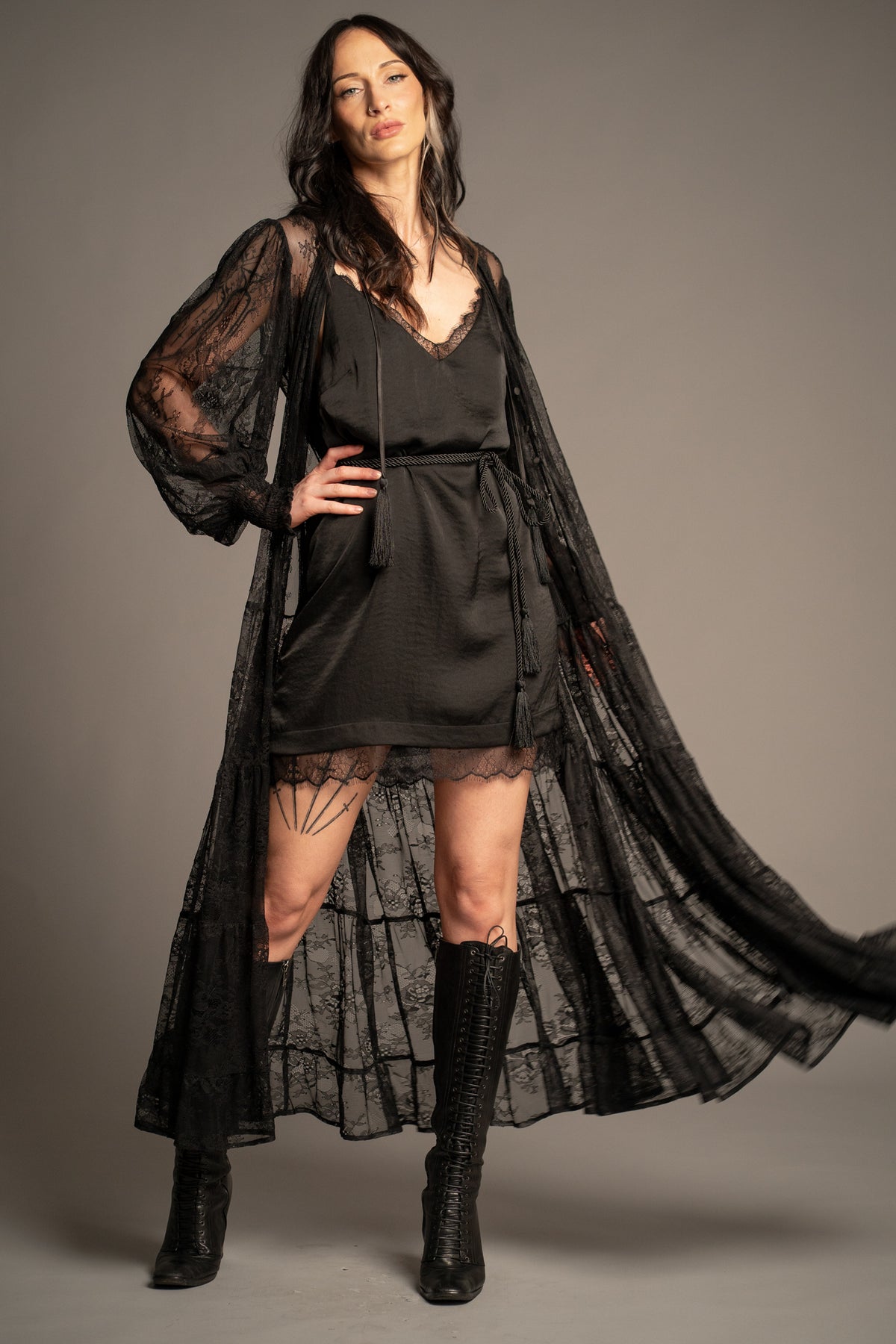 Rhiannon black lace maxi dress worn open as a lace duster featuring sheer floral lace, tassel ties and flowing tiered silhouette