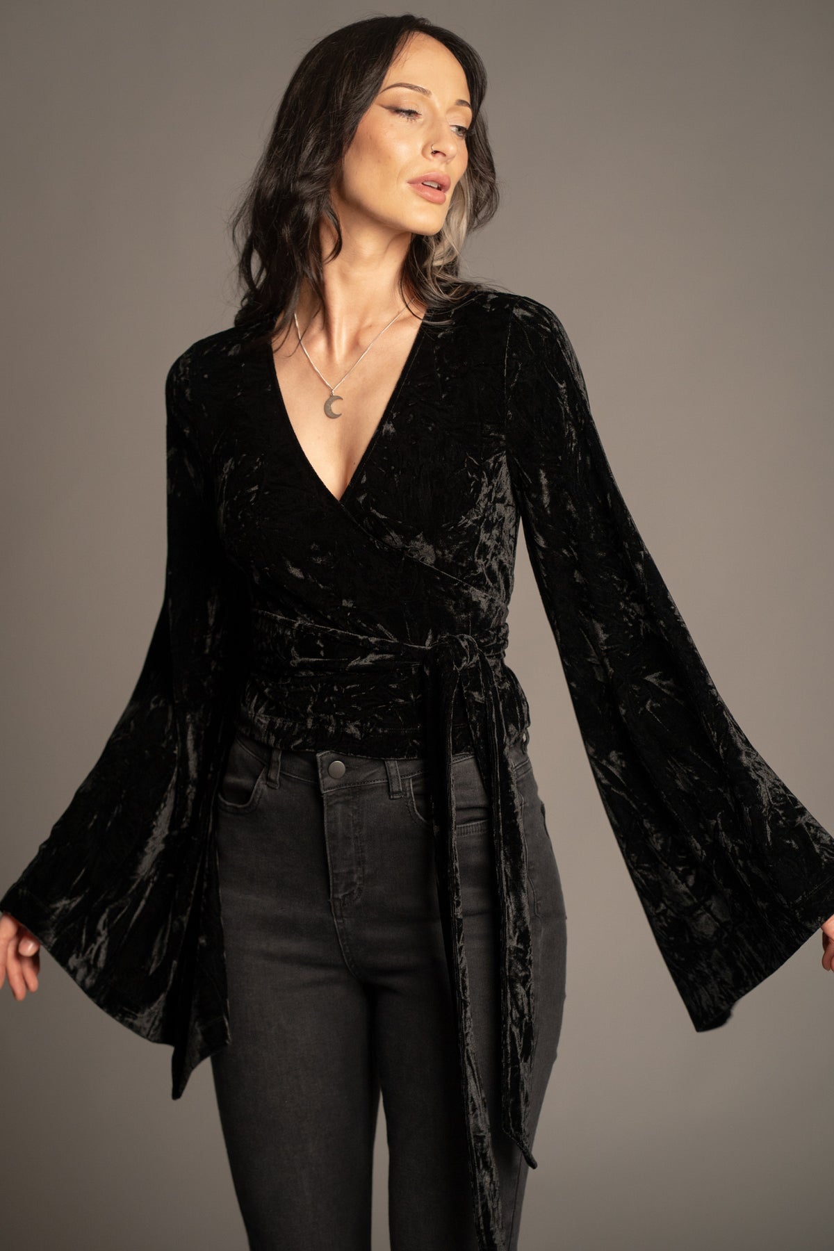 Sally black velvet wrap top with tie waist detail and dramatic bell sleeves front view