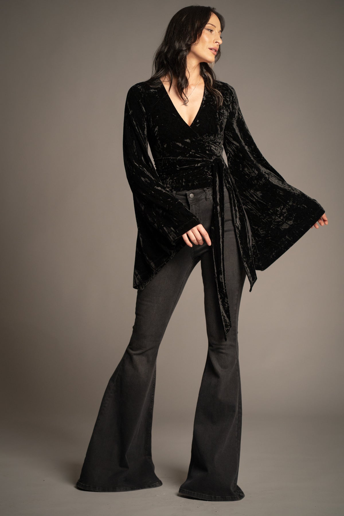 Sally black velvet wrap top with tie waist detail and dramatic bell sleeves front view