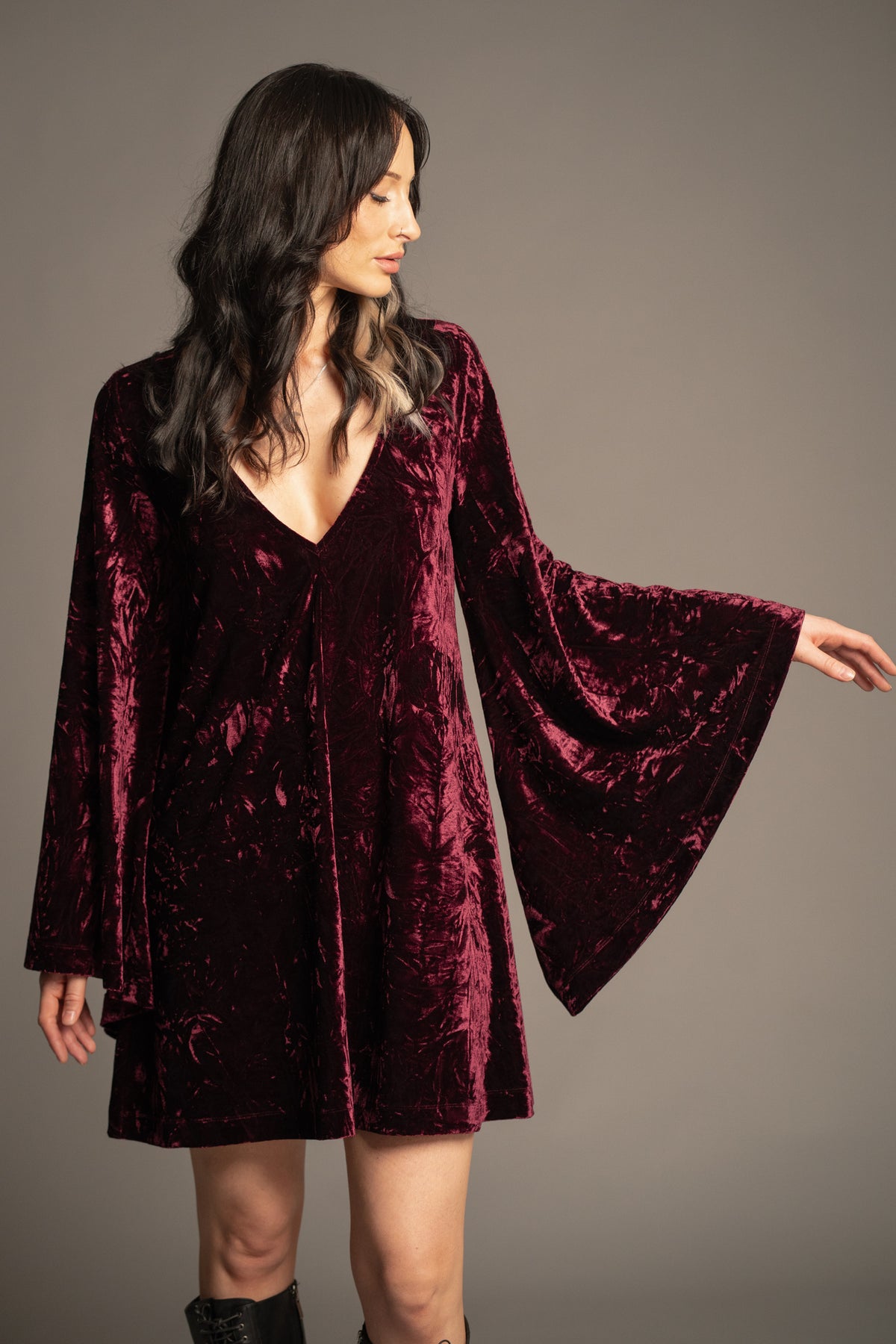 Close-up of Sara merlot velvet mini dress showcasing deep V-neckline, luxurious crushed velvet texture and bell sleeve detail