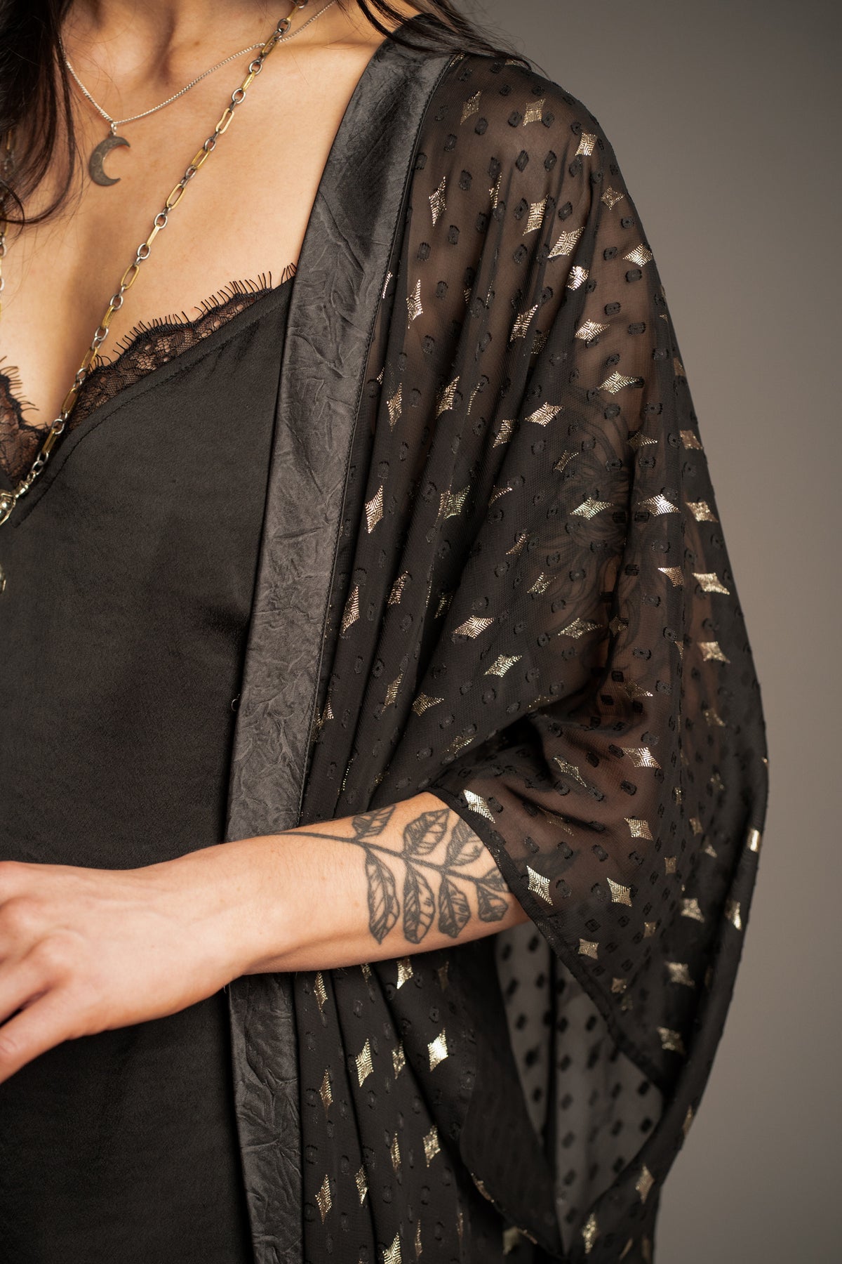 Close-up of Songbird black metallic kimono featuring metallic star print, lightweight sheer fabric and flowing sleeve detail