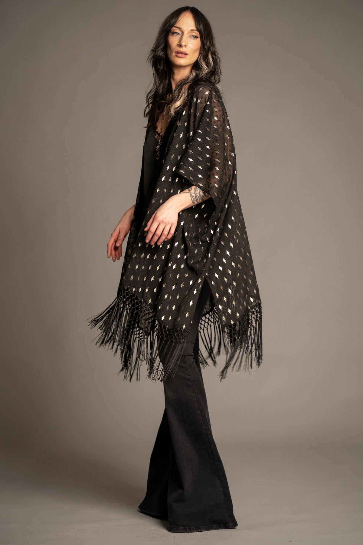 Songbird black metallic kimono side view featuring shimmering gold foil detailing, lightweight sheer fabric and fringe hem