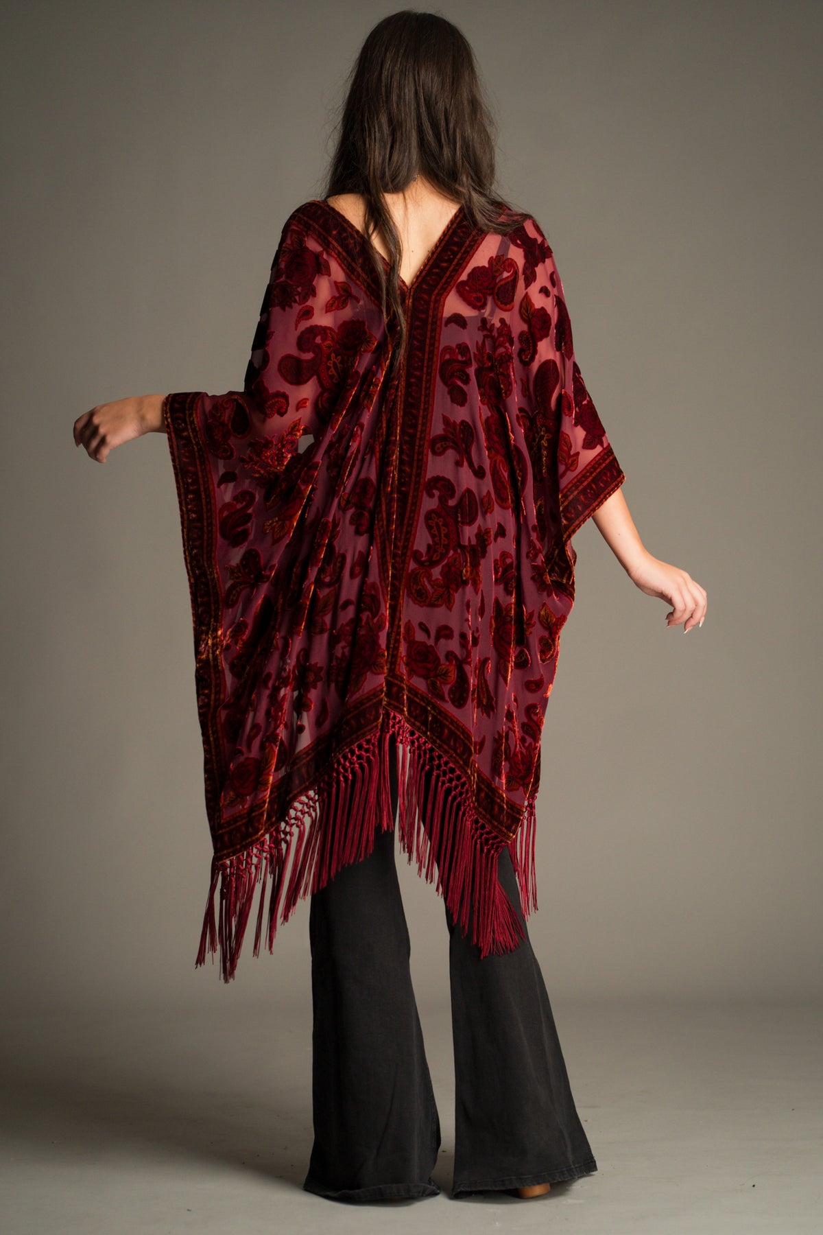 Back view of the Stevie Plum Paisley Devore Kimono featuring a striking paisley devore pattern, fluid drape and statement tassel fringe trim