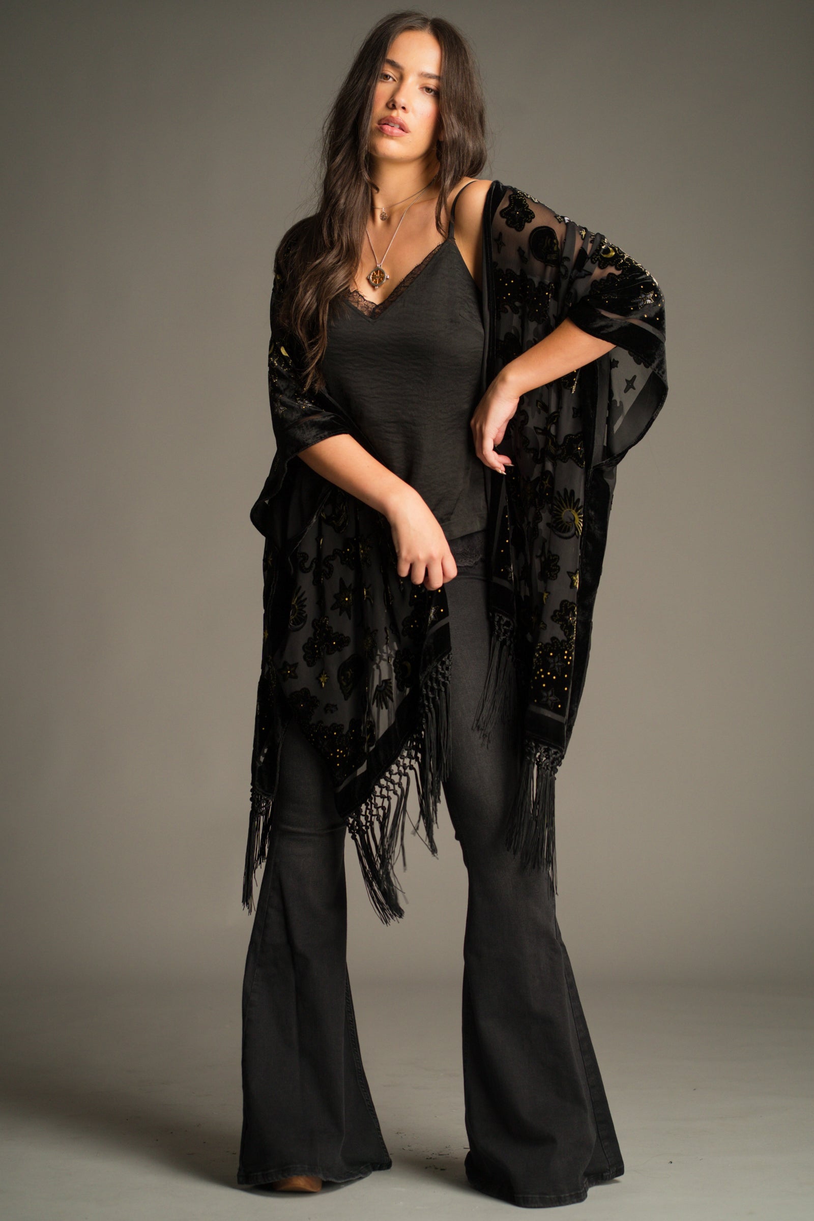 Suzi Skull Black Devore Kimono by Little Lies featuring a sheer black velvet burnout fabric, skull and celestial motif design, statement fringe trim and flowing bohemian silhouette