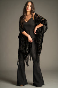 Suzi Skull Black Devore Kimono by Little Lies featuring a sheer black velvet burnout fabric, skull and celestial motif design, statement fringe trim and flowing bohemian silhouette