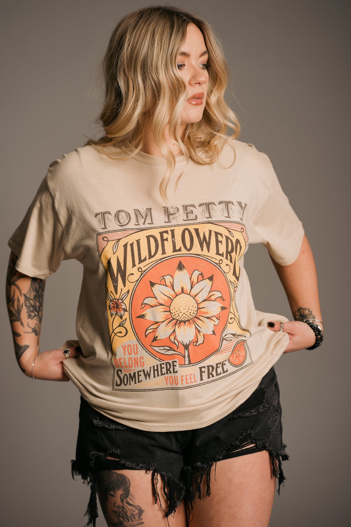 Close-up of Wildflowers album artwork in warm yellow and orange tones on Tom Petty band tee