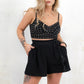 Model wearing Woodstock Flippy Shorts- Black double cheesecloth fabric shorts with high waisted silhouette and elasticated shirred waistband and tassel tie detail