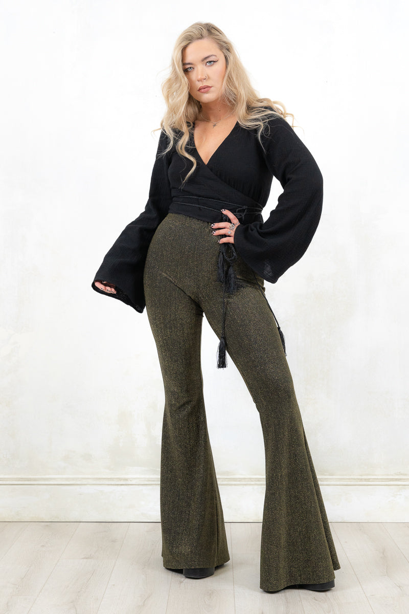 Model wearing Hendrix Metallic Flares - black/gold metallic  flares with major retro bell bottom