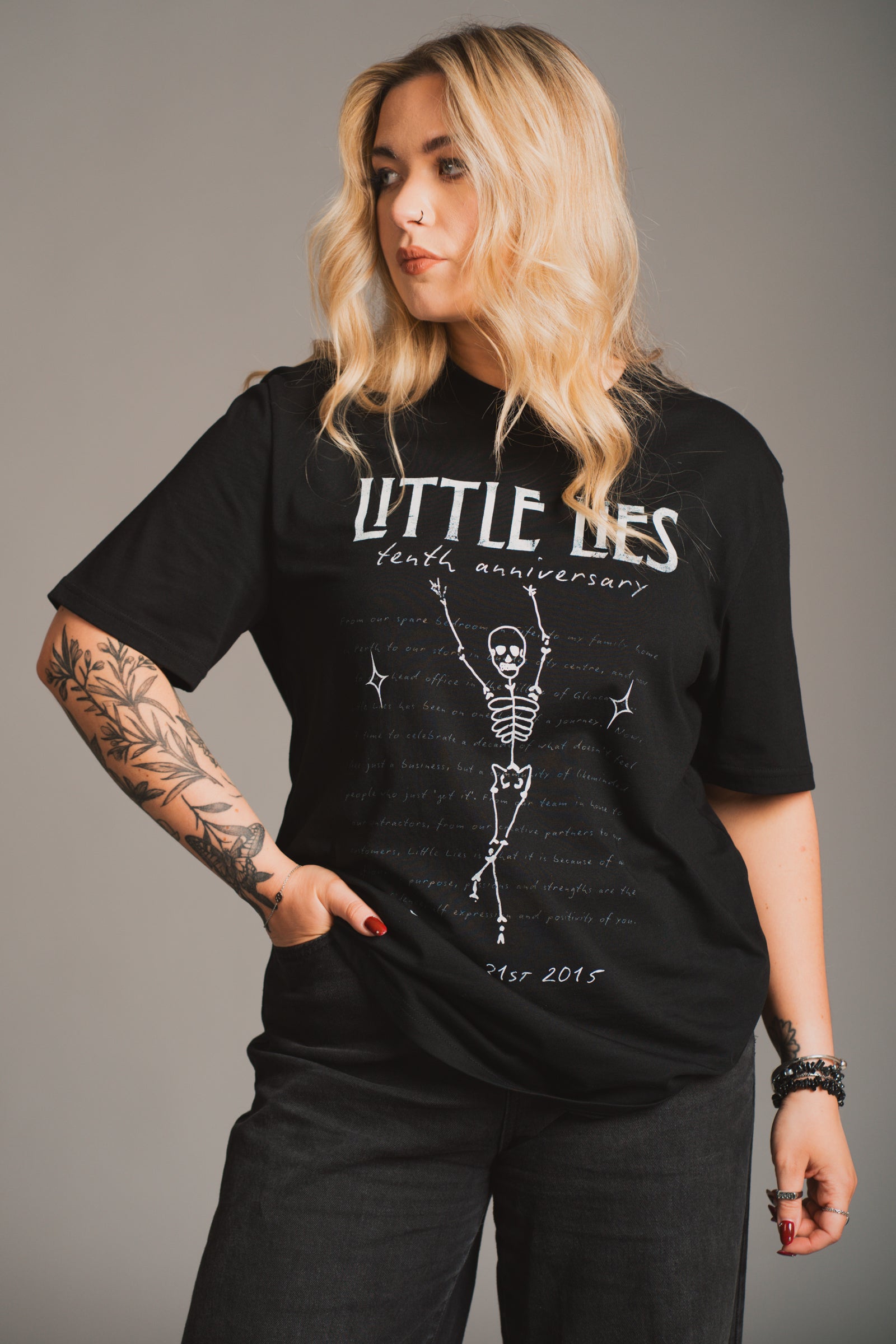 Model wearing Little Lies 10th Anniversary Graphic black t-shirt with vintage Little Lies design.