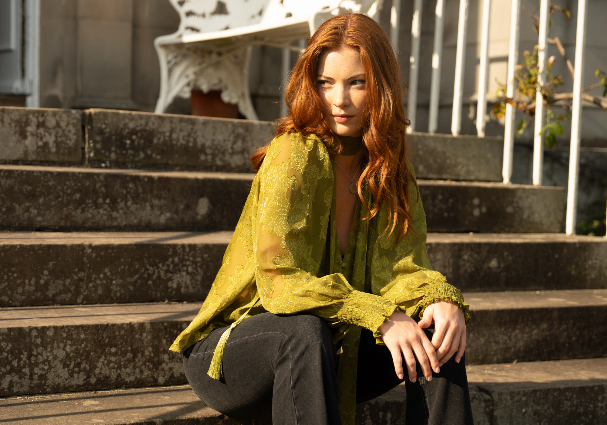 Anna wearing Cassia Olive Chiffon Smock Top sitting in the sun on stone steps at the Byre at Inchyra estate