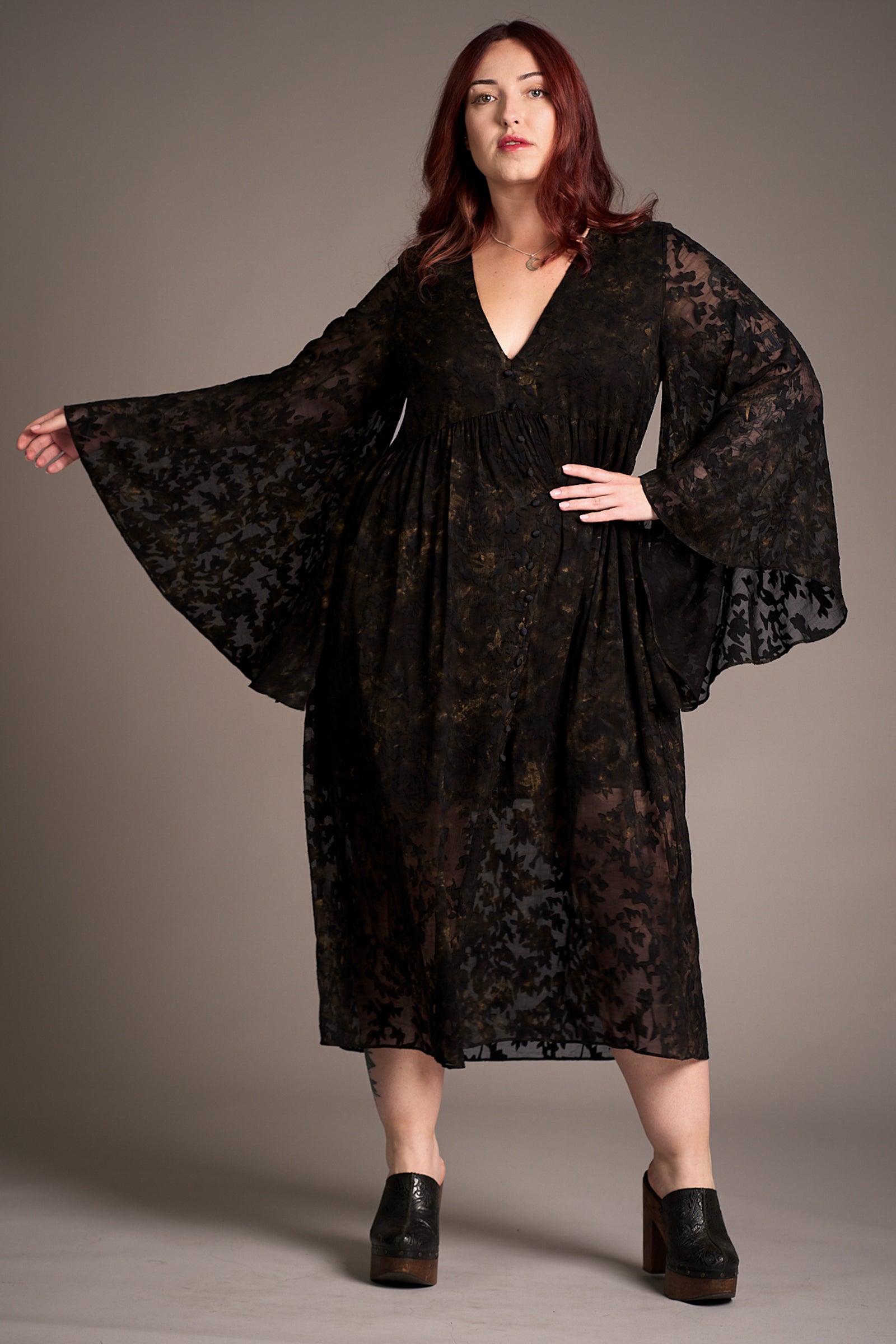 Taylor wearing Bella Donna Midi Dress featuring deep V-neckline, sheer floral sleeves, against a neutral backdrop, Stevie Nicks inspired styling studio