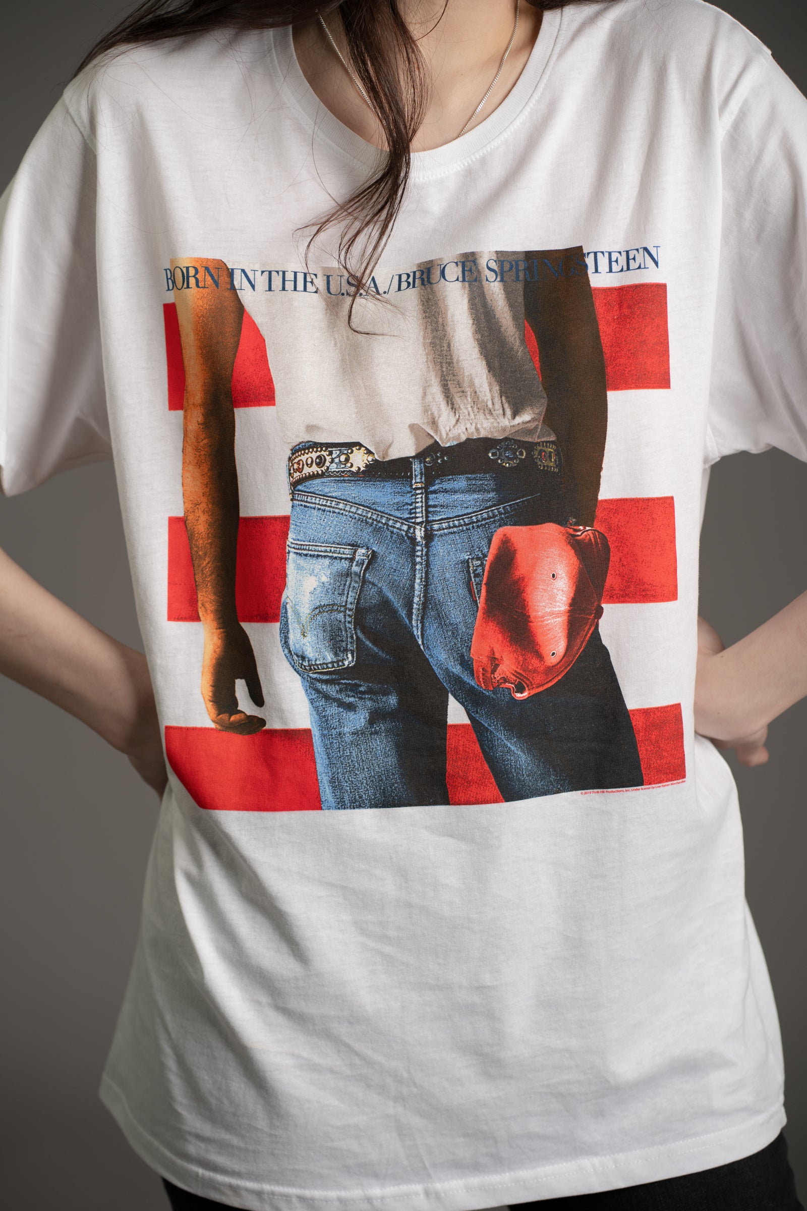 Close-up of Bruce Springsteen Born in the USA album cover graphic on white oversized tee from Little Lies collection