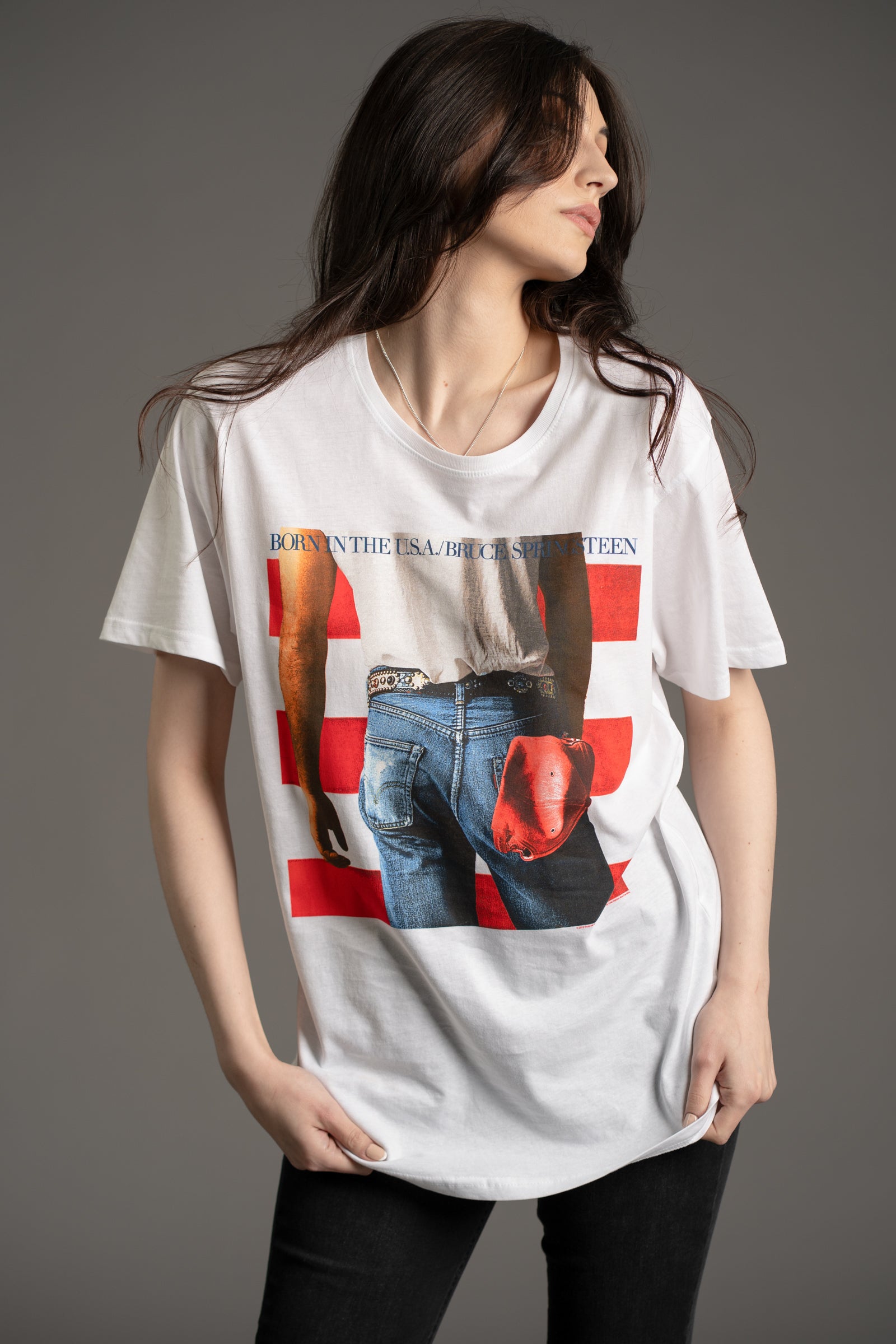 Front view of model Andie wearing the  Bruce Springsteen Born in the USA graphic band tee in white featuring iconic album cover design from Little Lies collection