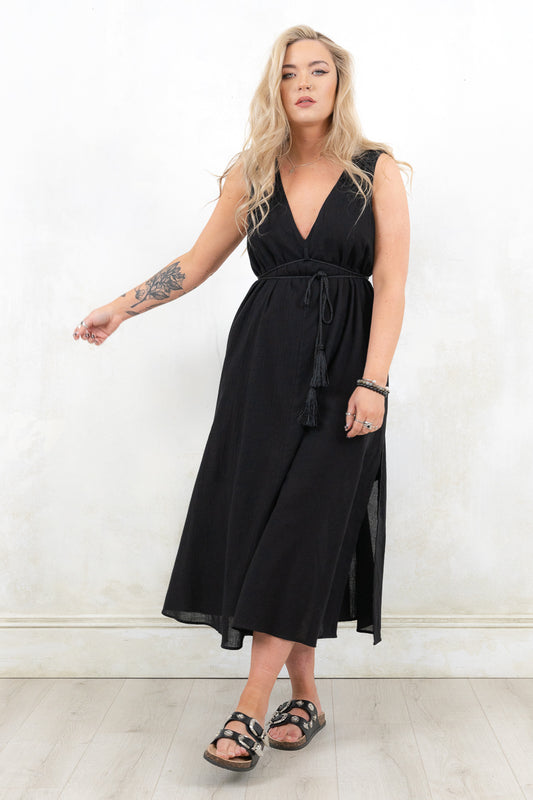 Model wearing Ramble On Midi Dress- Black tassel tie midi dress. With three ways to tie, Ramble On gives the options of a trapeze silhouette, empire fit or a cinched in waist. 