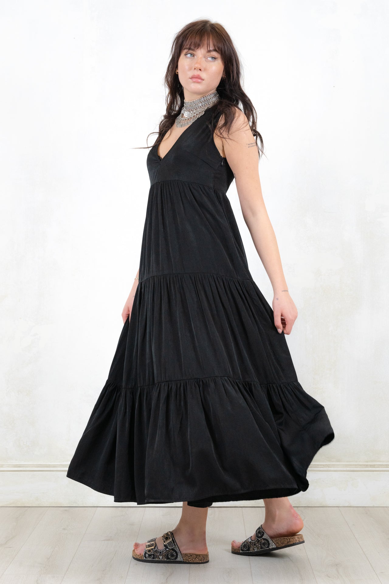 Model wearing Strange Magic Maxi Dress, a Black Sleeveless smock shape dress with side zip closure and tiered hem