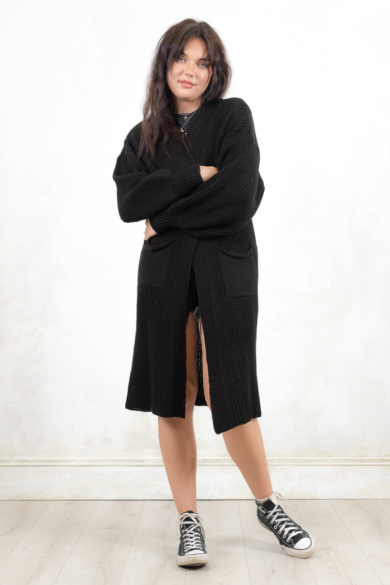 Model wearing All Apologies Black Cardigan - Black oversized knit cardigan , Open front with true pockets