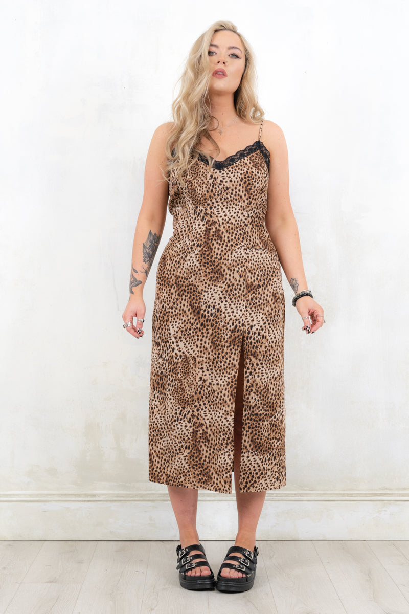 Model wearing Lithium Leopard Slip Dress, a leopard print midi dress with concealed side zip closure, side split, adjustable straps and lace trim
