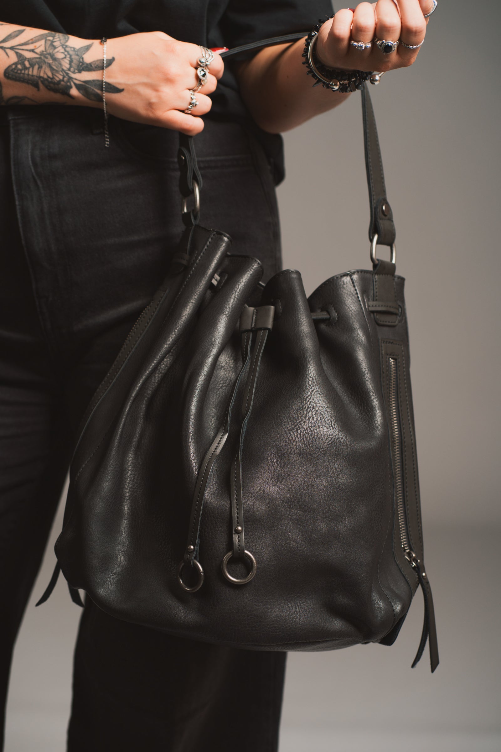Model holding the Dakota Black Hobo Bag in front of a black background. 