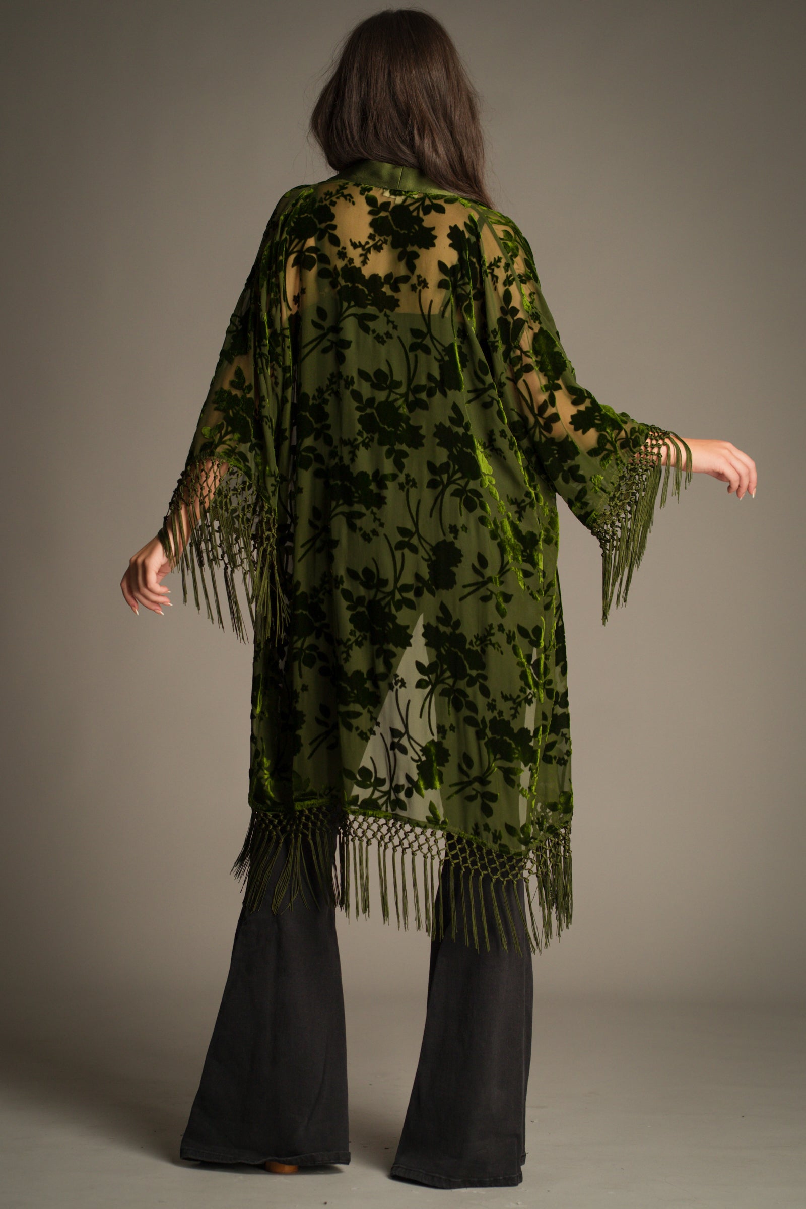 Back view of Little Lies Dakota olive devore kimono with sheer fabric, velvet floral pattern and flowing silhouette with tassel fringe