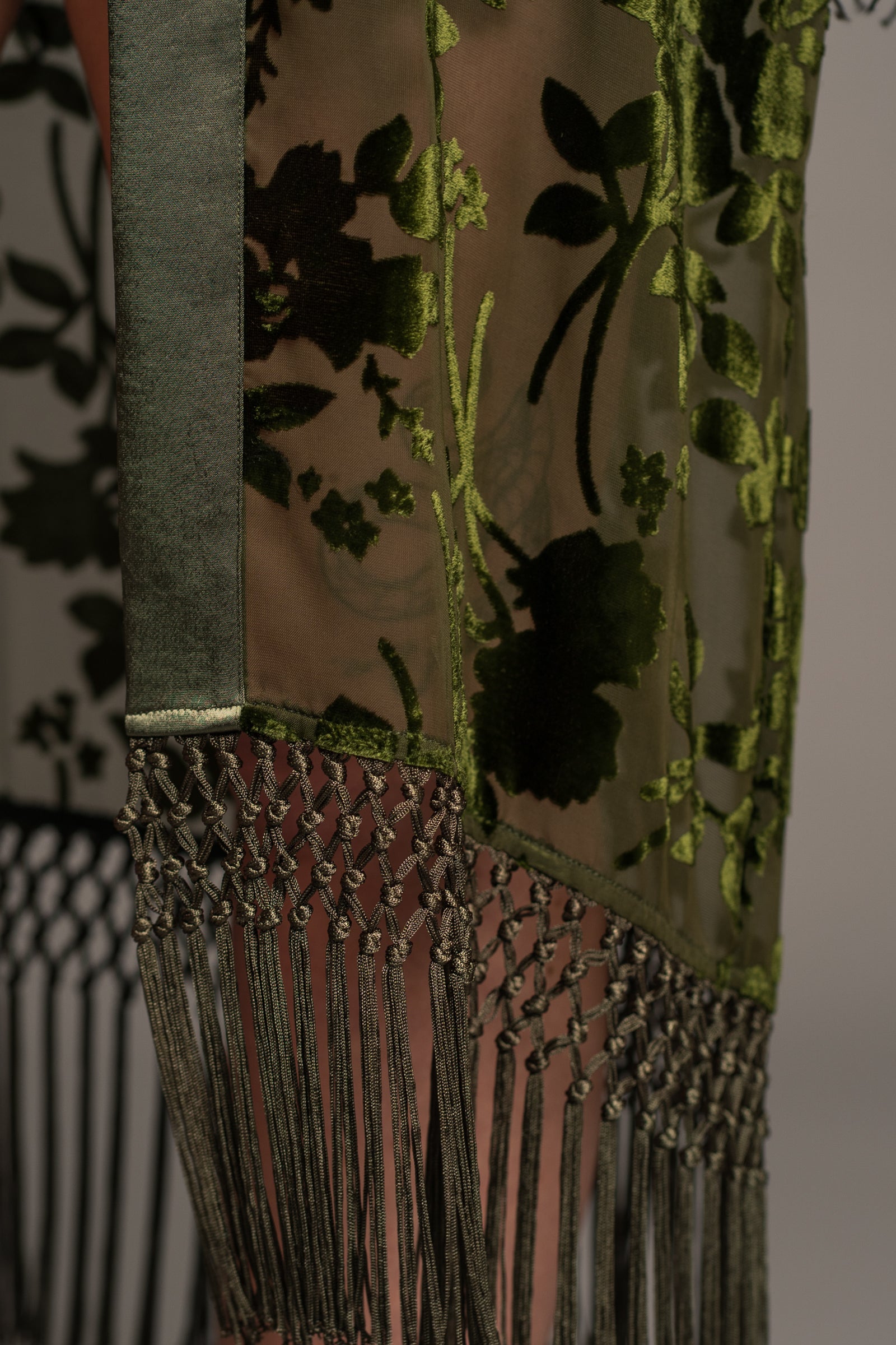 Close-up of Little Lies Dakota olive devore kimono showing velvet floral fabric and detailed tassel fringe along hem