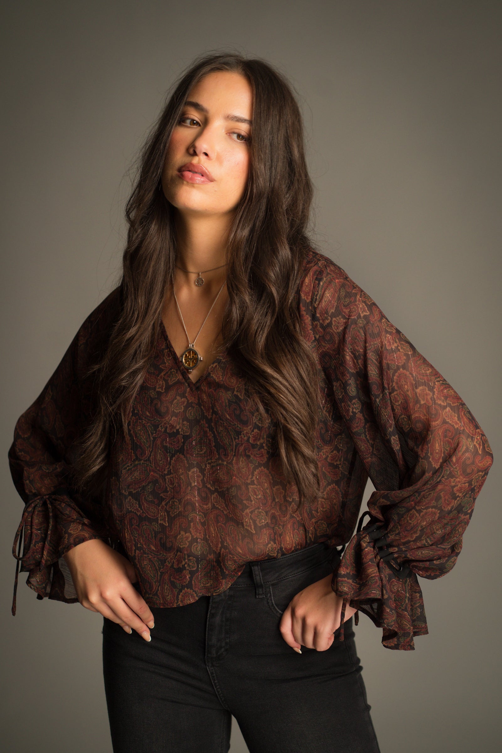 Front view of the Dark Paradise Paisley Boho Top in sheer wine, rust and emerald paisley chiffon. Styled with Hendrix Black Denim Flares.