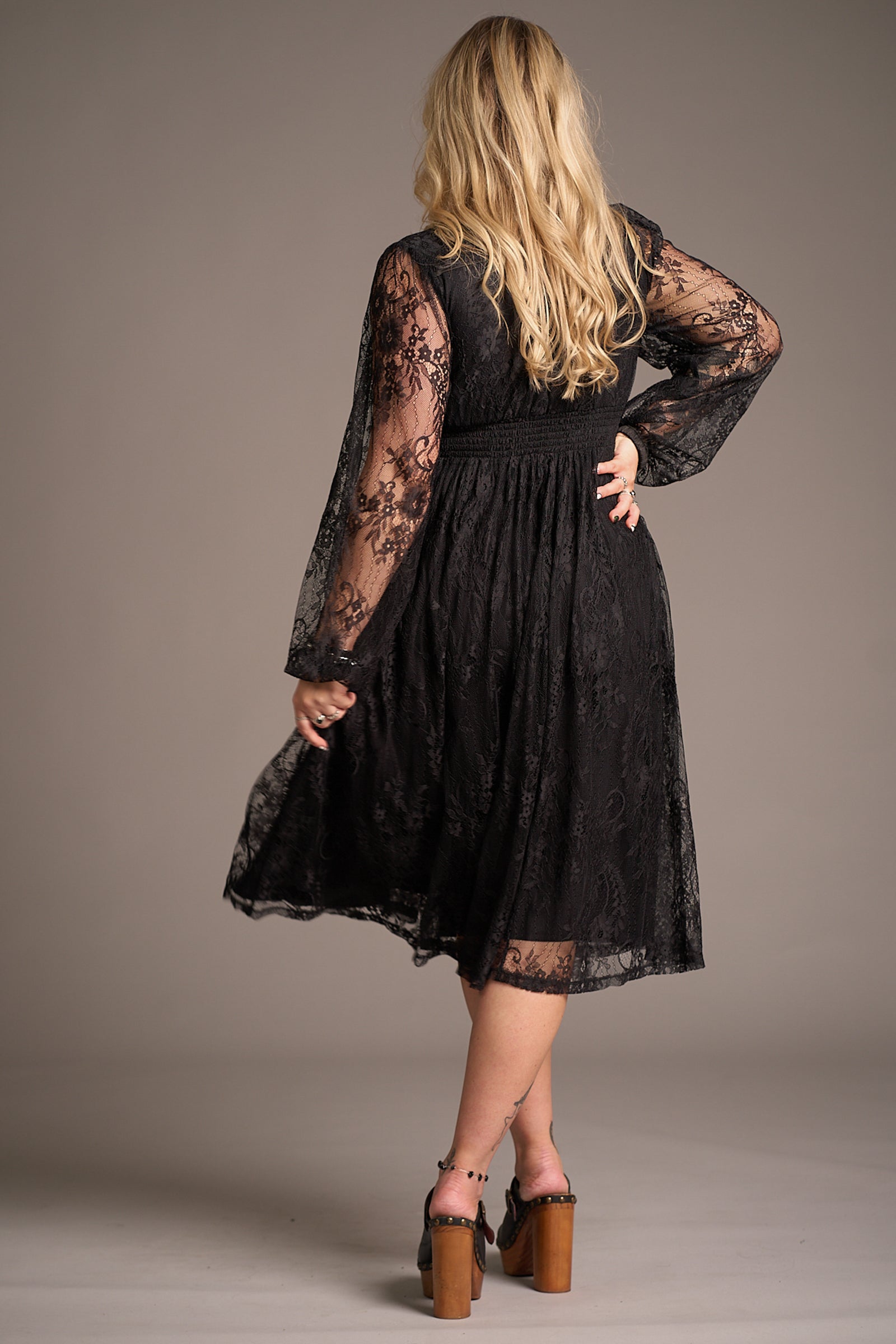 Erin showing the back of the Dazed Black Lace Midi dress, highlighting elegant lace detail and flattering A-line fit. Stevie nicks inspired styling studio