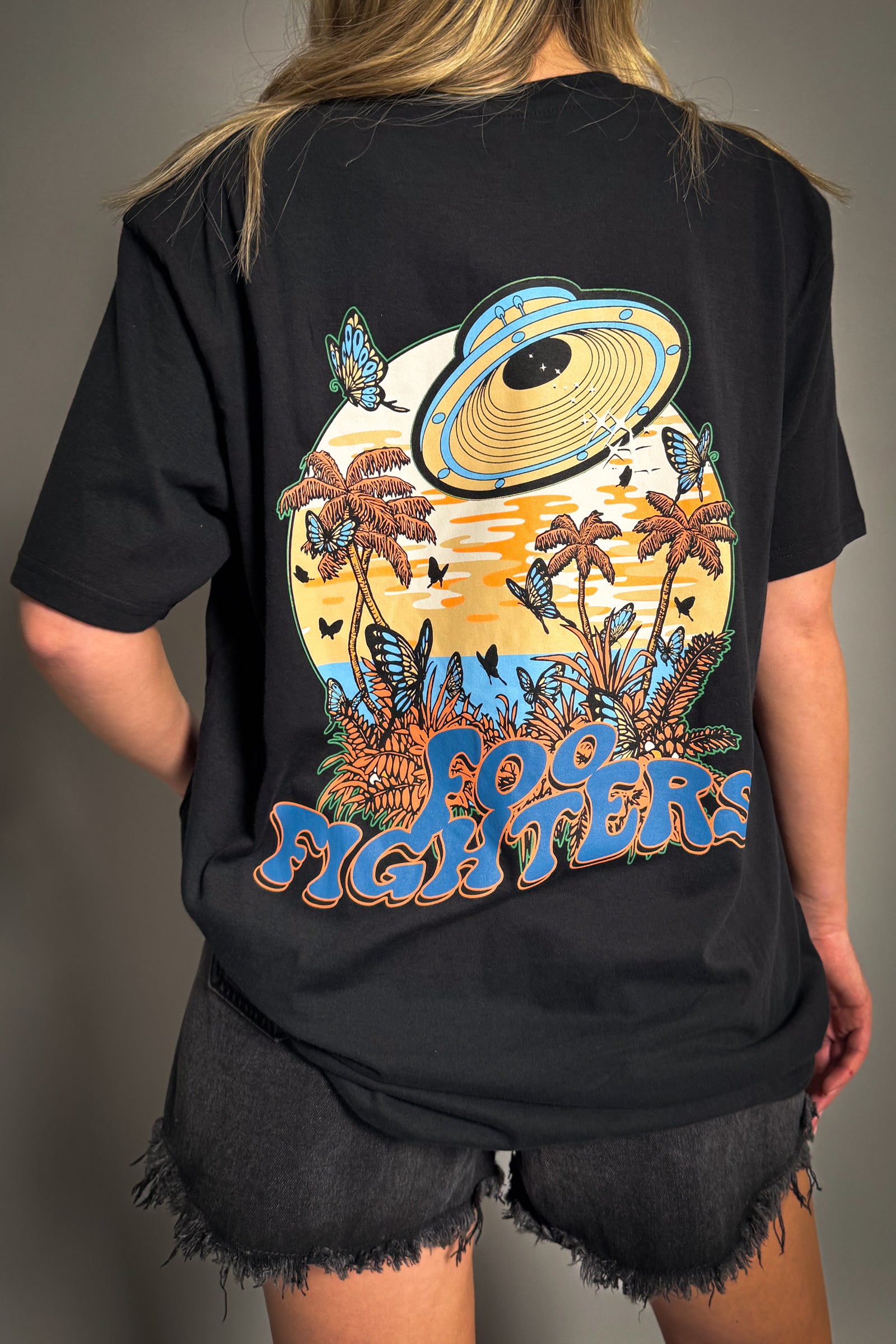 Back view of Little Lies Foo Fighters space butterflies band tee with colourful graphic featuring UFO, palm trees and butterfly design