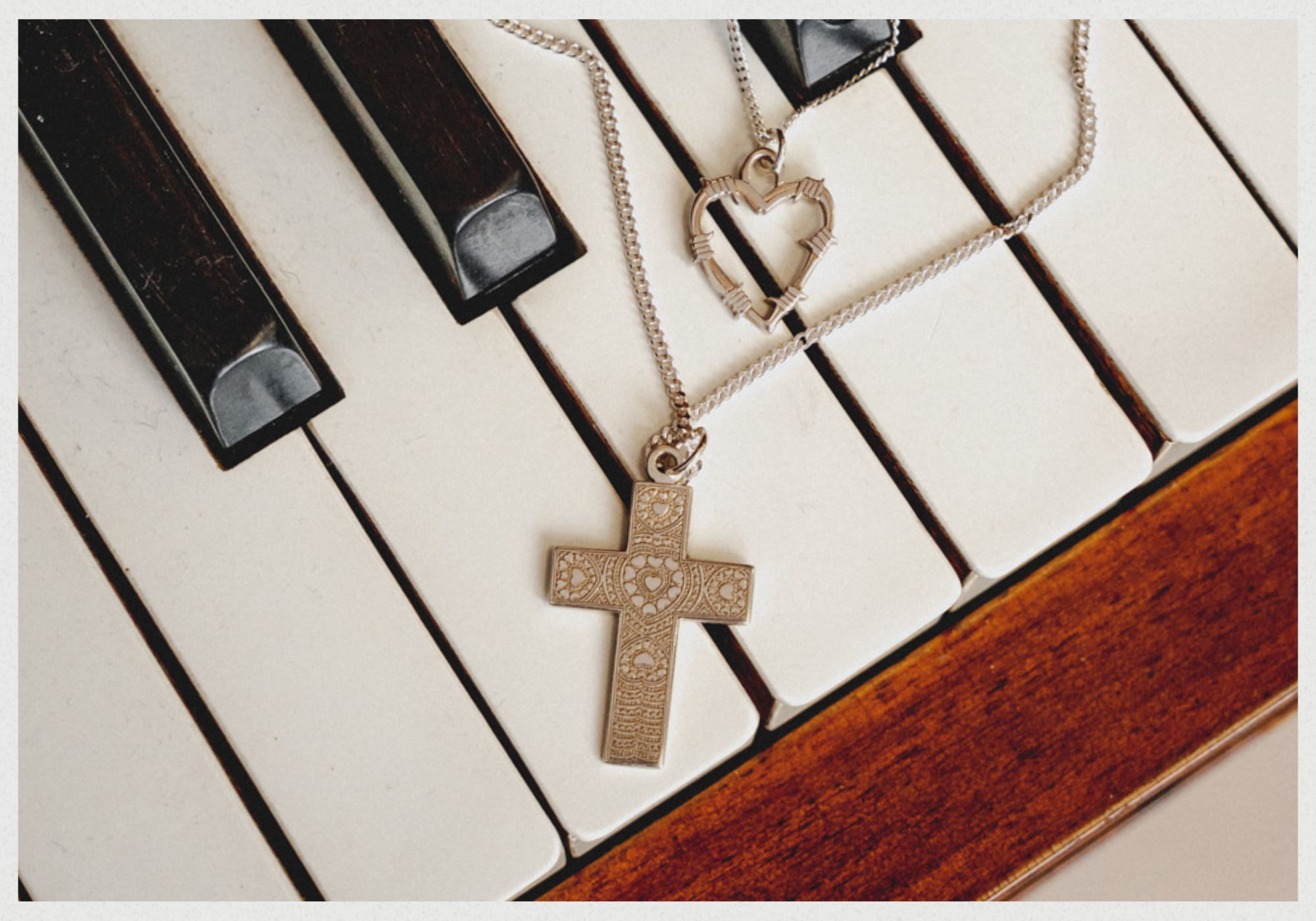 Sterling Silver Barbed Heart and Cross necklaces on Piano keys